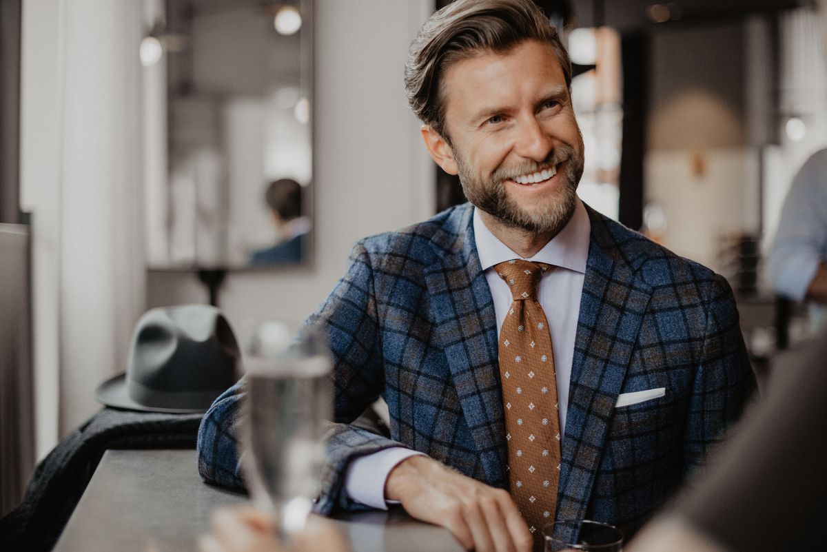 Man with beard wearing a blue and brown checkered suit by Oxxford Clothes