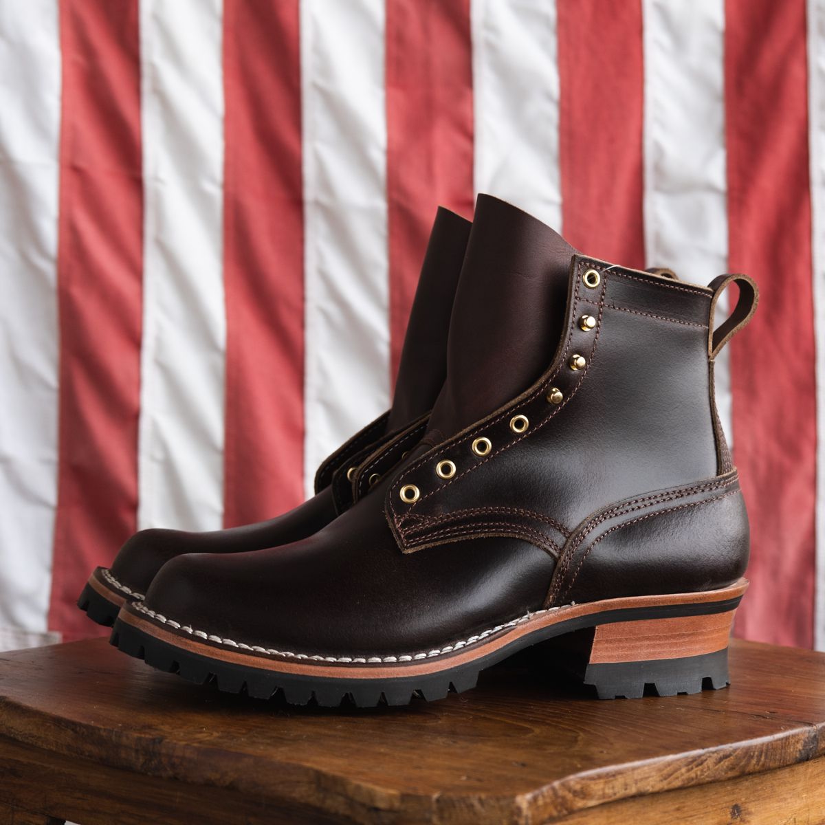 Pair of Nicks Handmade Boots on wooden table with American flag in background