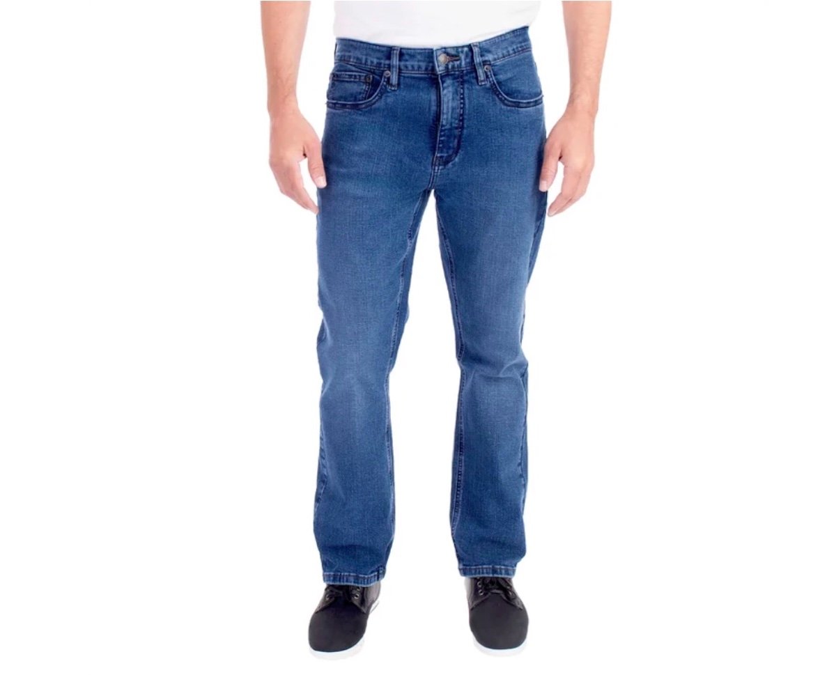 A person wearing blue straight-leg jeans, a white shirt, and black shoes—possibly showcasing one of the best Costco finds—is shown from the waist down against a plain white background.