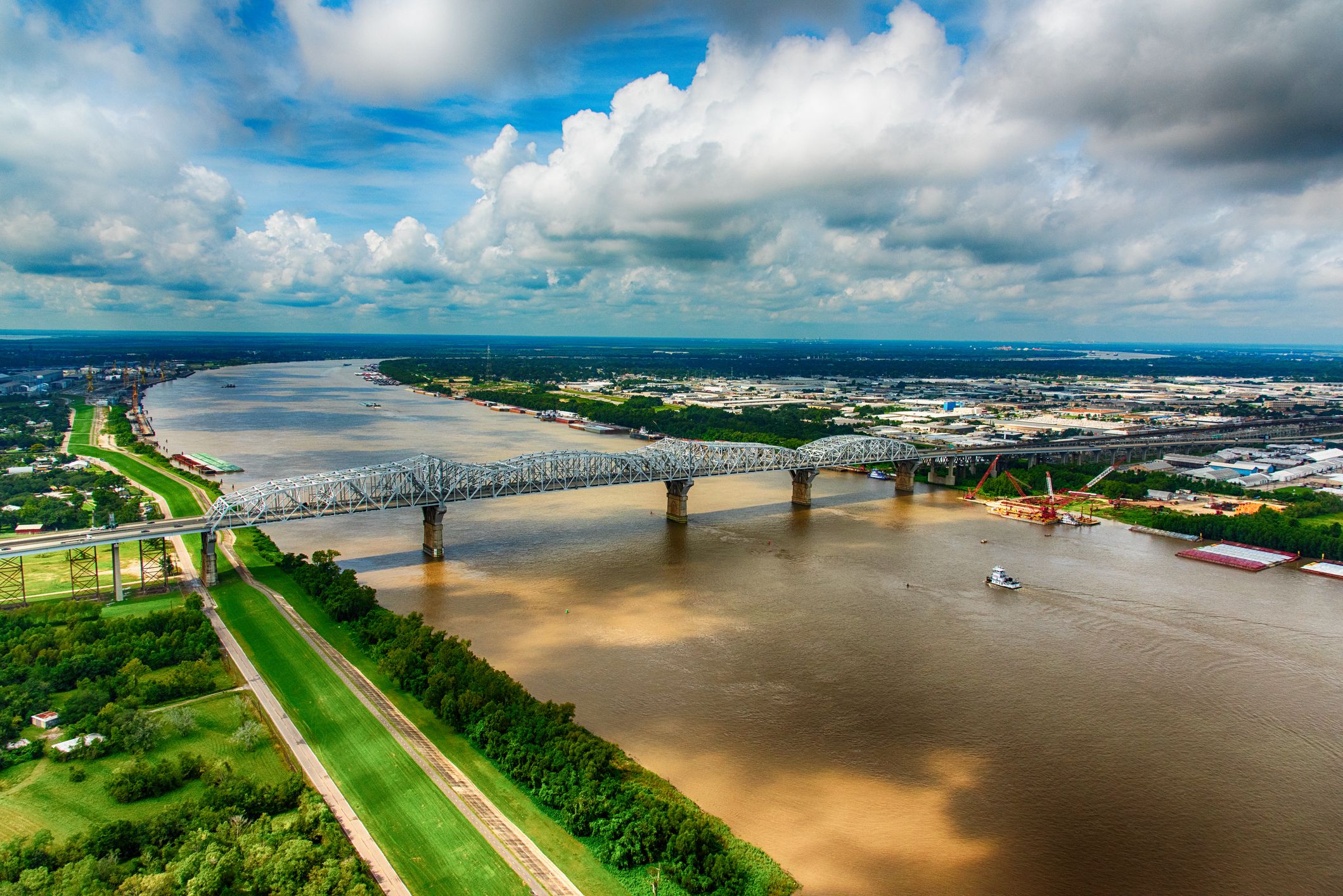 A tug boat moving toward a bridge spanning the mighty Mississippi River in southern Louisiana near New Orleans.