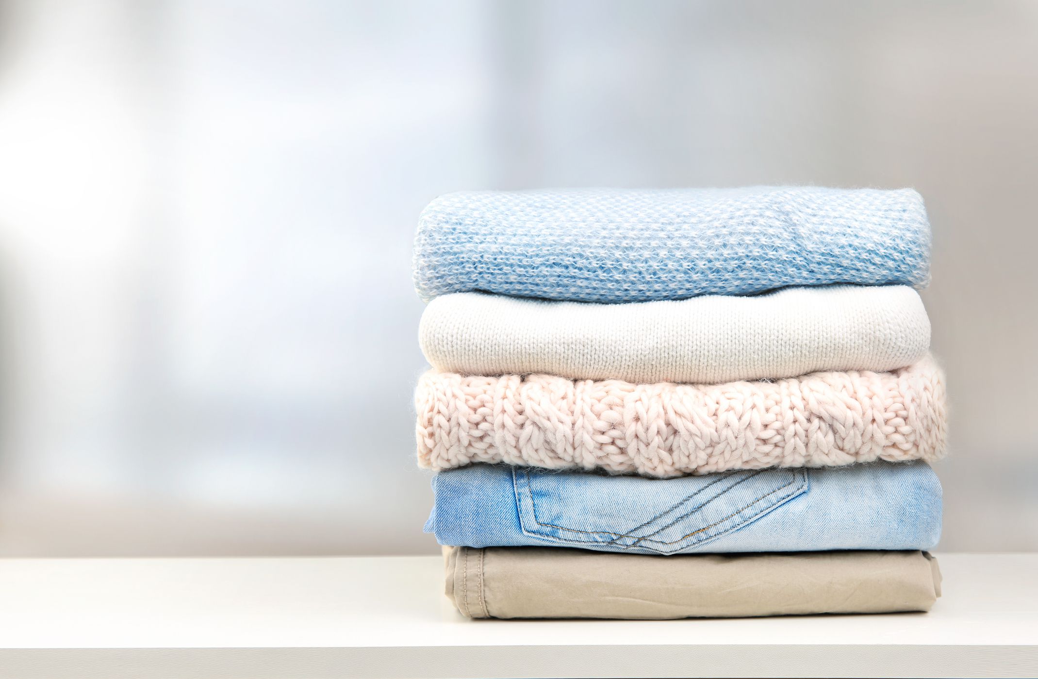 Stack of clothes on table empty space background.