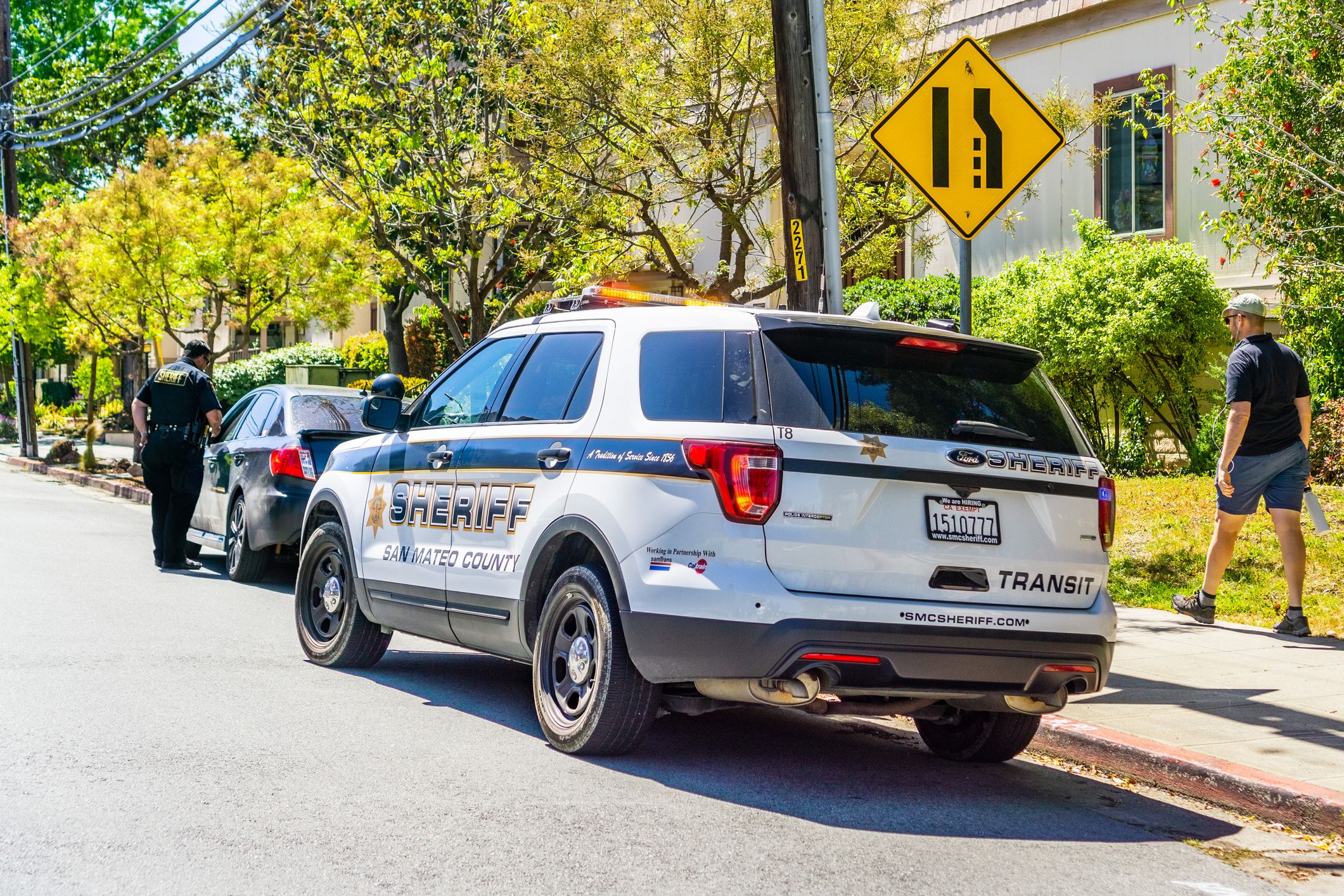 sheriff pulling over car on right side of road in california