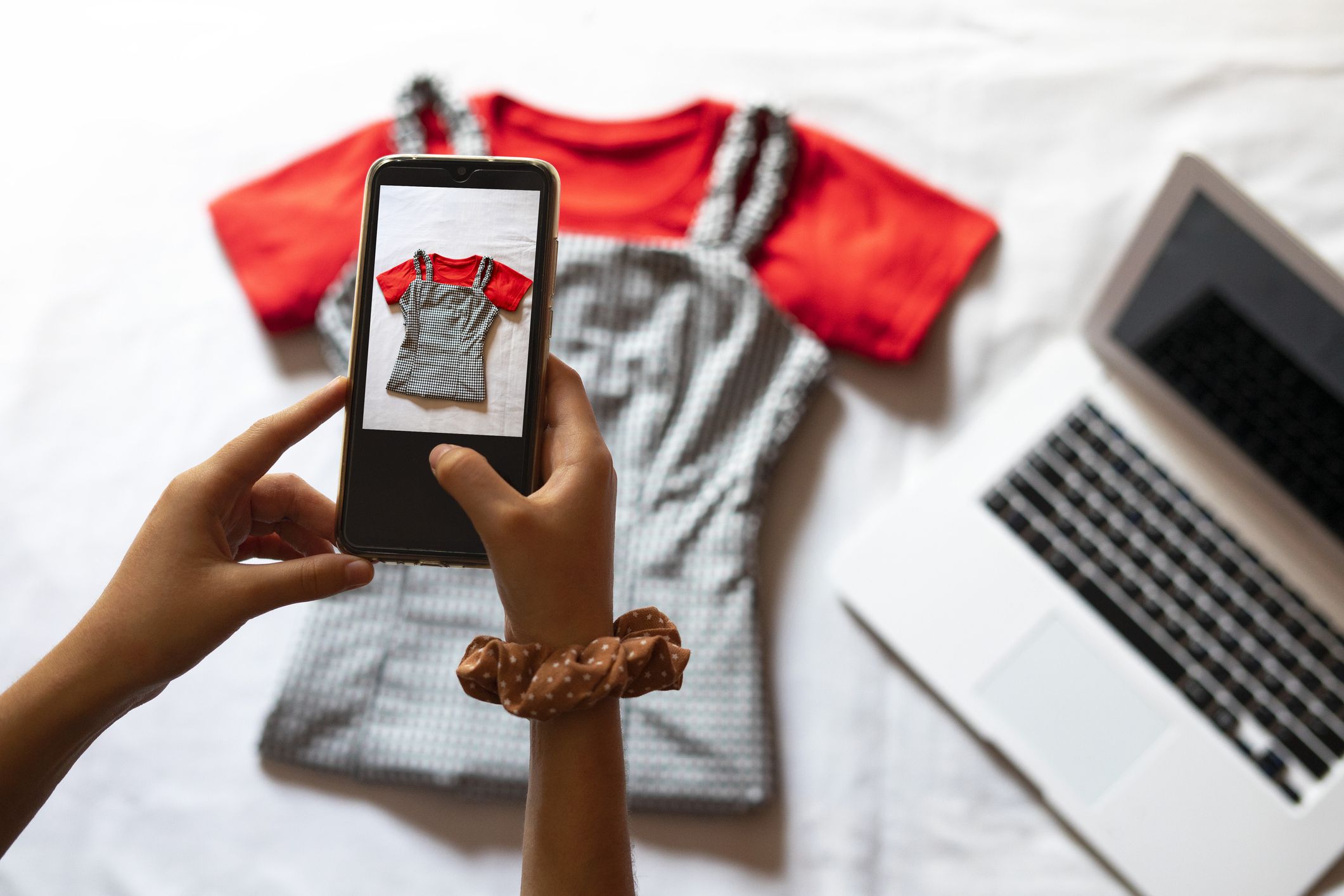 Woman taking a photo of an article of clothing to sell online