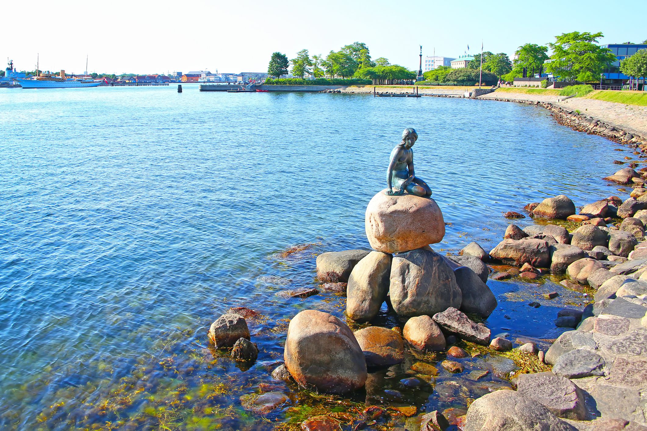 Langelinie promenade with the iconic little mermaid statue & landmark in the foreground and the harbour in the background, Copenhagen, Denmark.