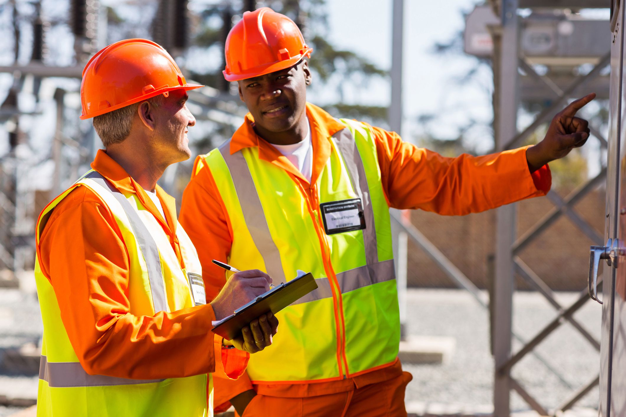 two industrial electricians taking machine readings at power plant