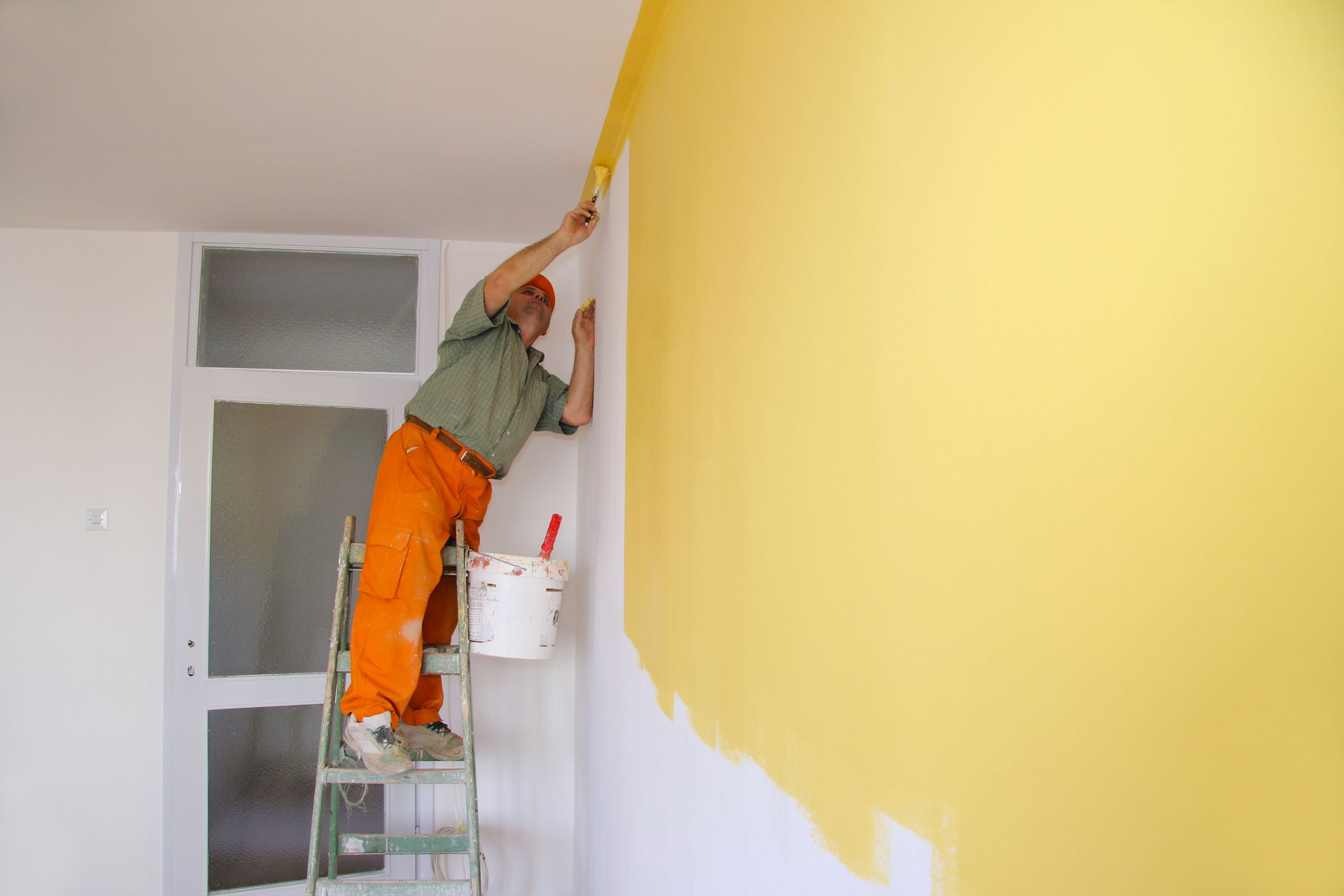 Senior man painting wall, interior decoration
