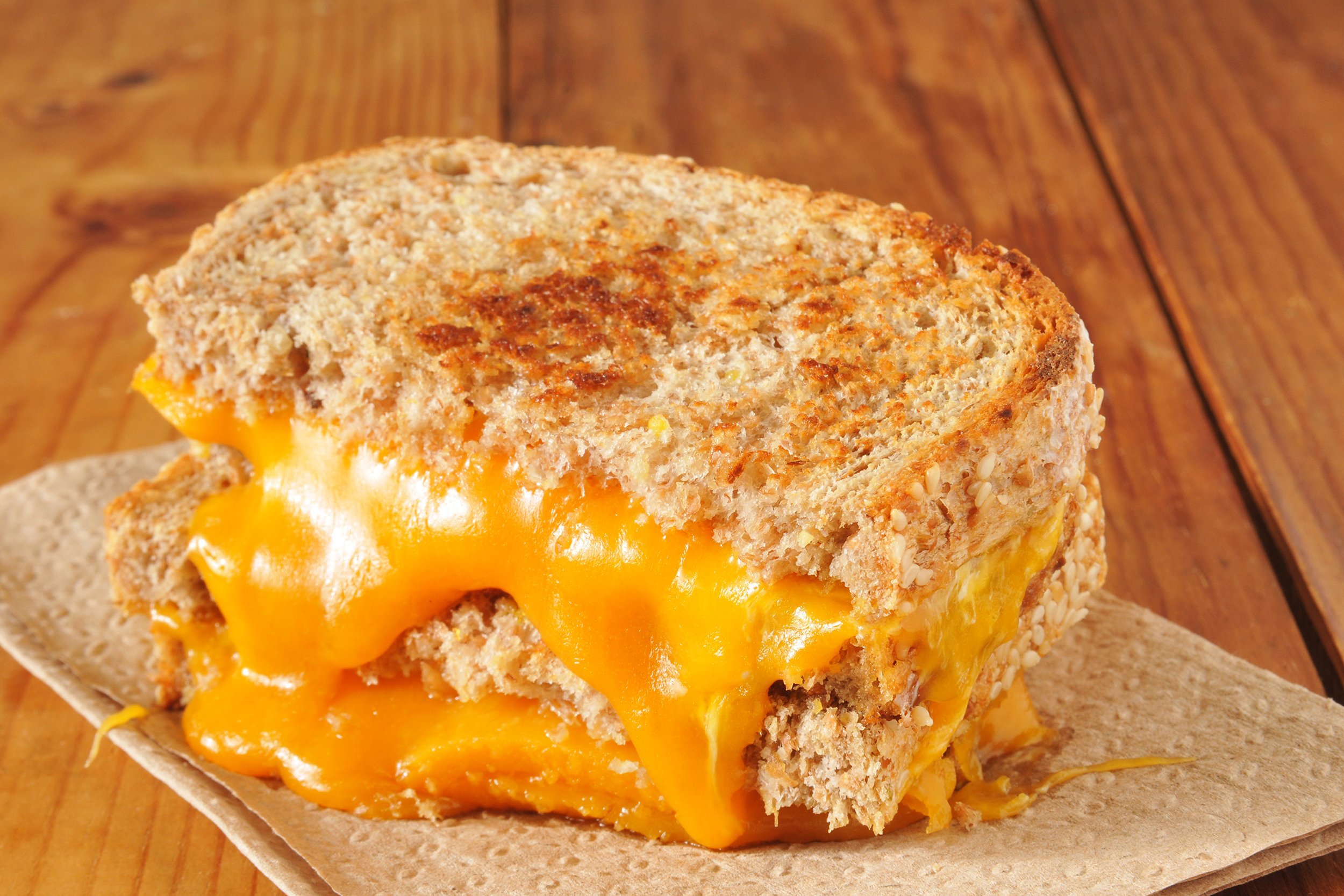 grilled cheese sandwich on whole wheat bread on wooden table