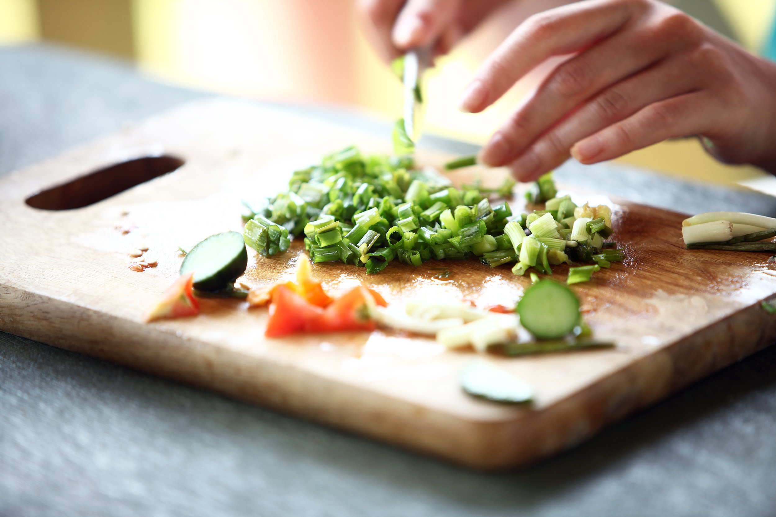 closeup of human hands cooking vegetables salad in kitchen
