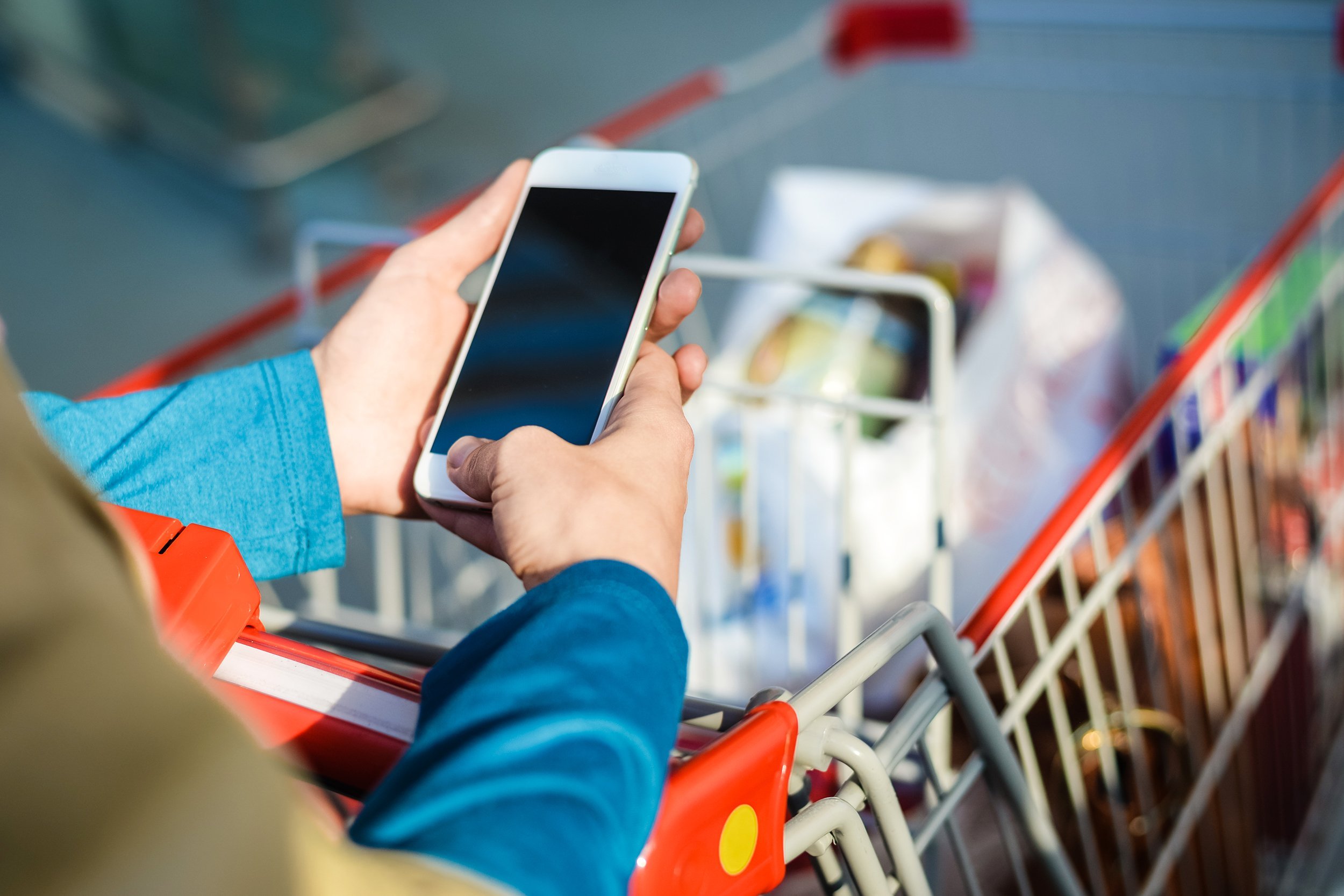 closeup on person holding mobile phone in hand during shopping
