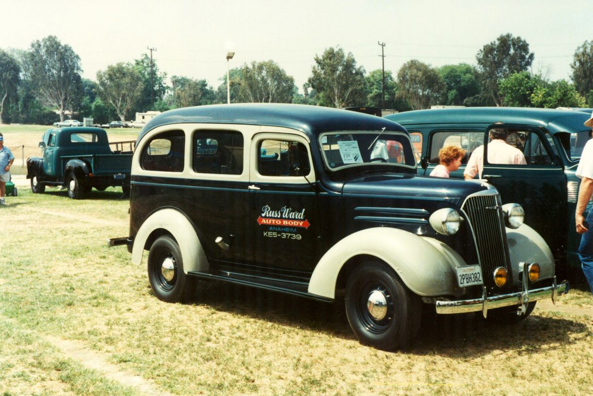Black and white 1937 Chevrolet Carryall Suburban parked on grass