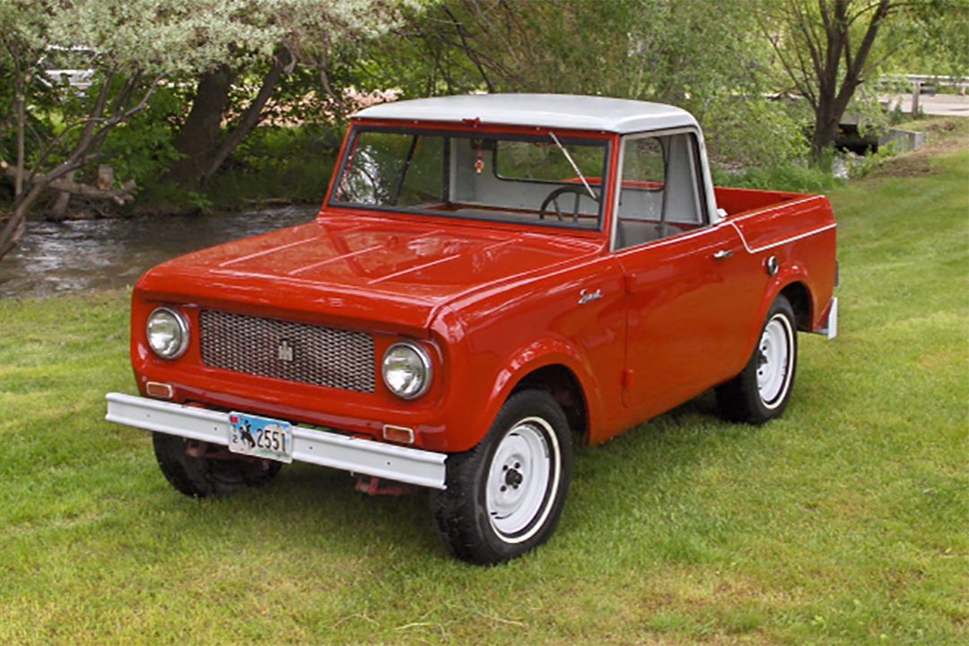 Restored red 1961 International Scout 80 parked on grass