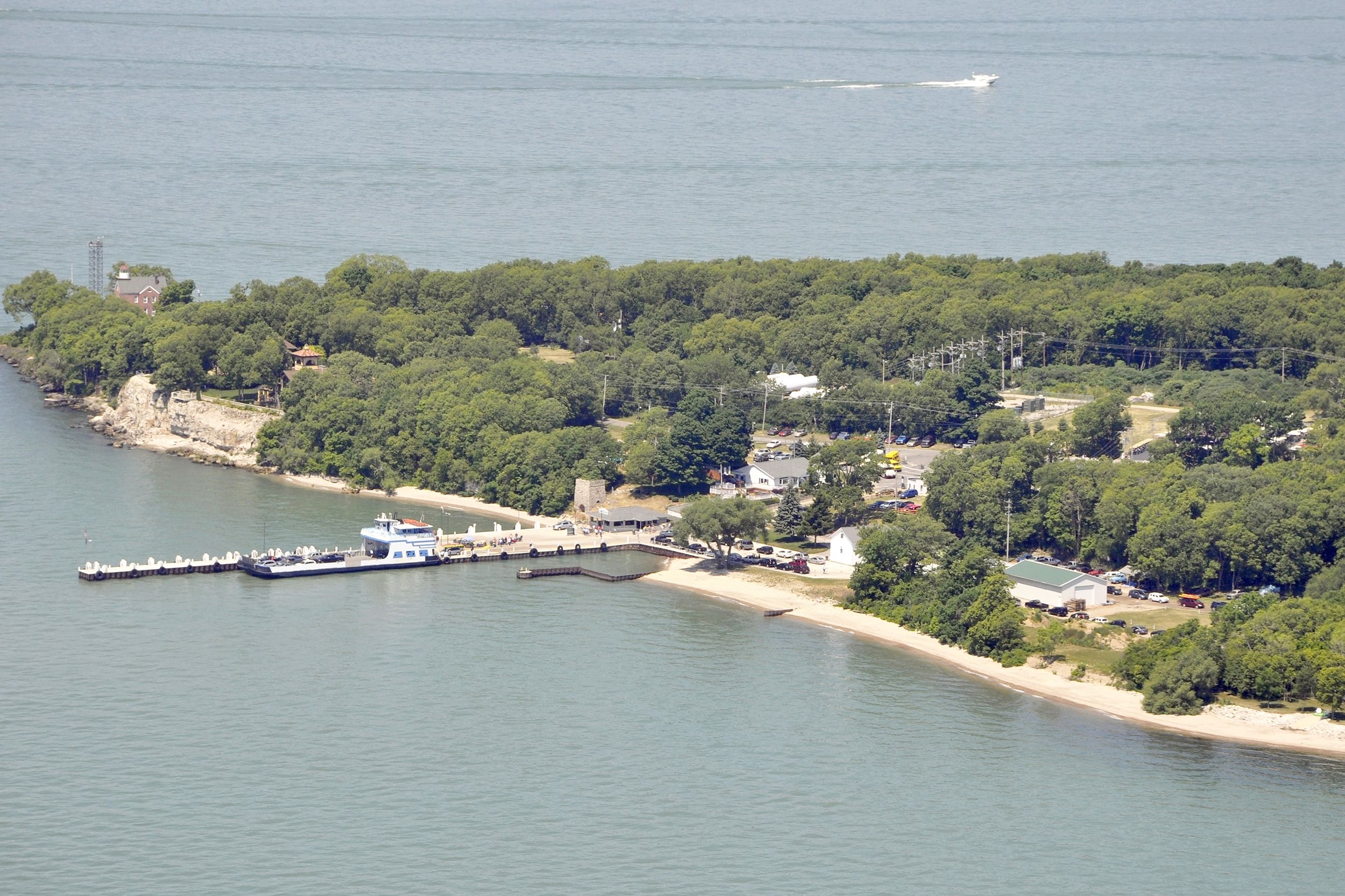 Aerial of Put-In-Bay, Ohio, triangular beach and shore, pier on the left, lots of trees on shore