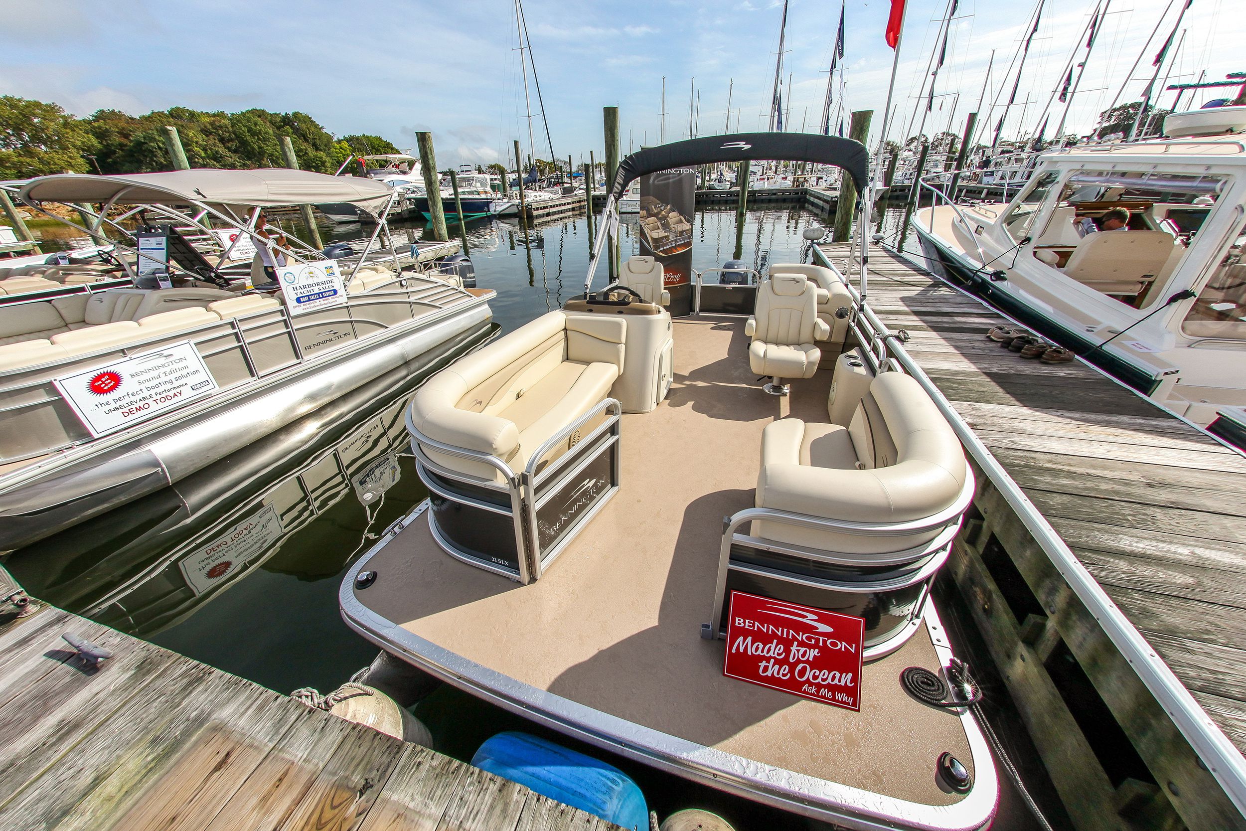 Boats in slip in the mariana, Norwalk, Connecticut, focus on three boats as seen from wooden walkway, on a sunny day during summer