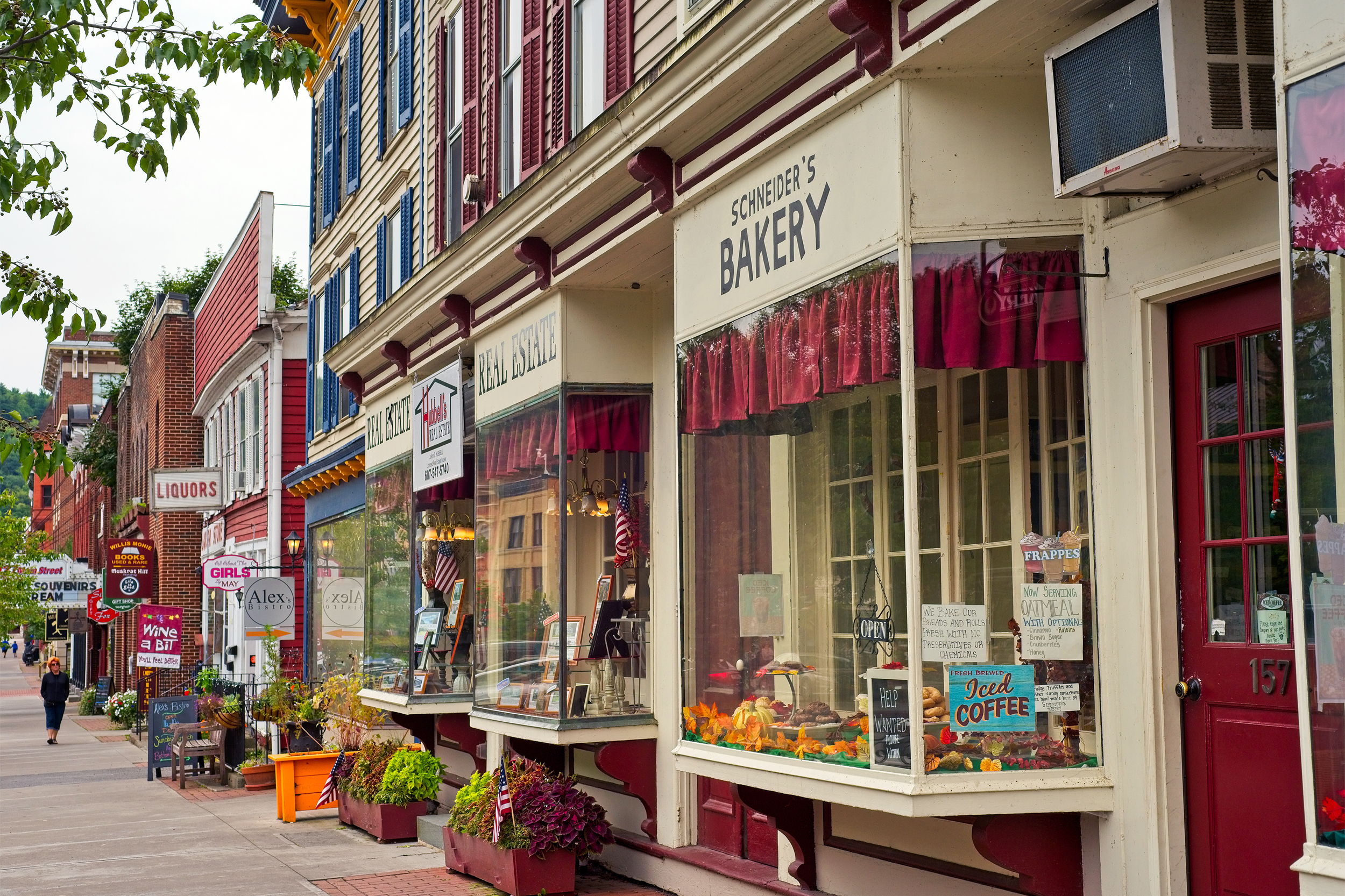 Charming shops on Main Street in Cooperstown, New York, buildings with a large sidewalk, during early late summer
