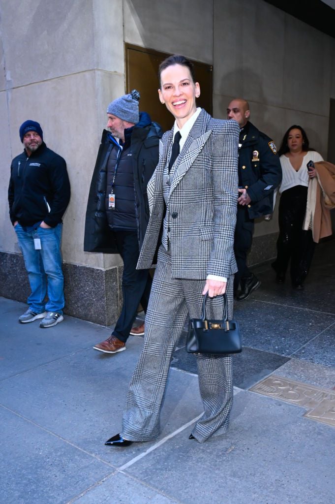 Hilary Swank smiling in a suit