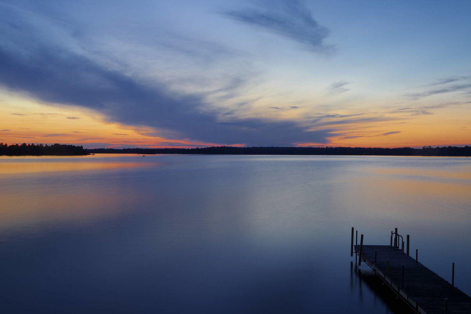 Lake Vermillion, Minnesota during early sunrise, lake in the foreground, line of trees in the background