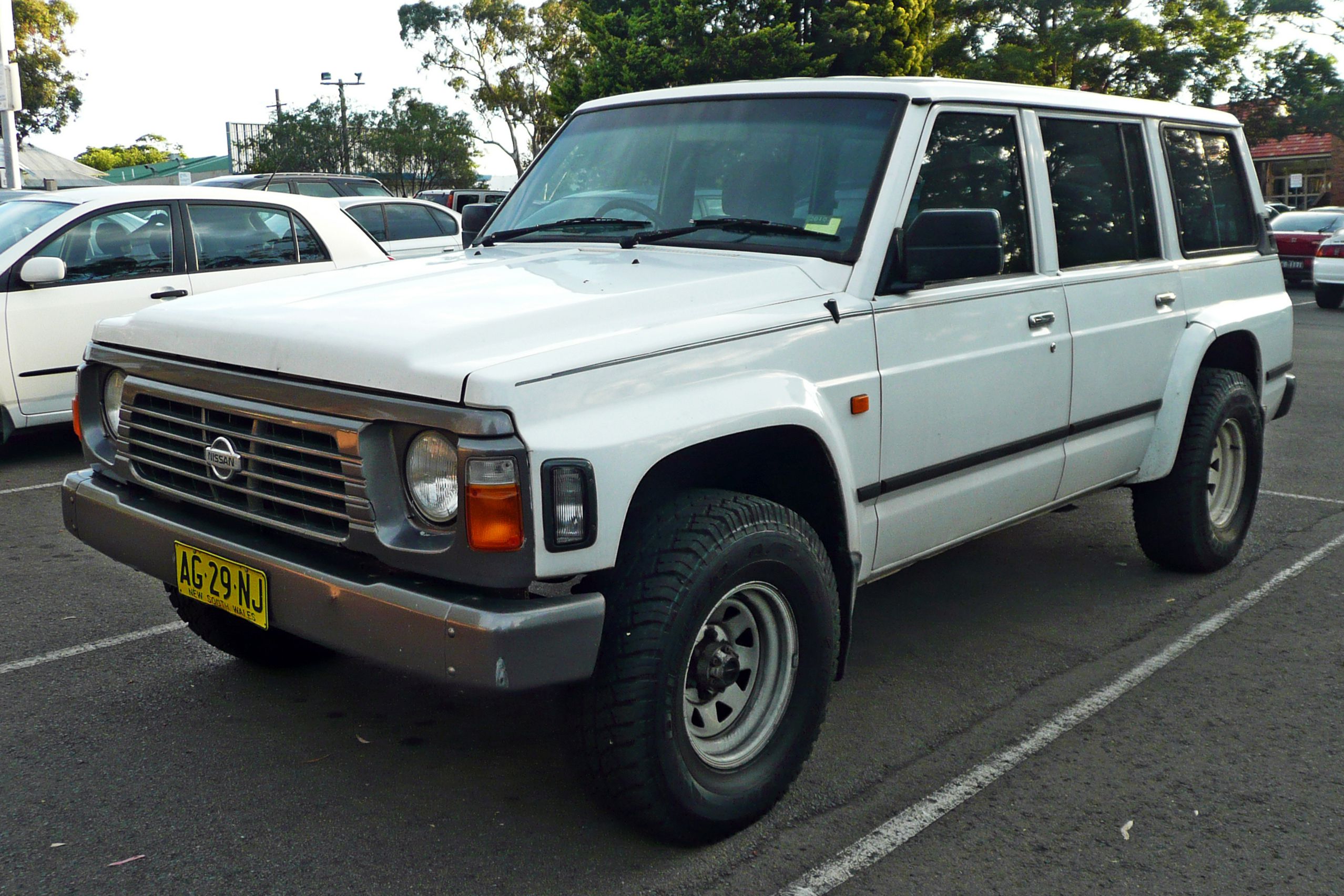 White Nissan Patrol Y60 in parking lot.