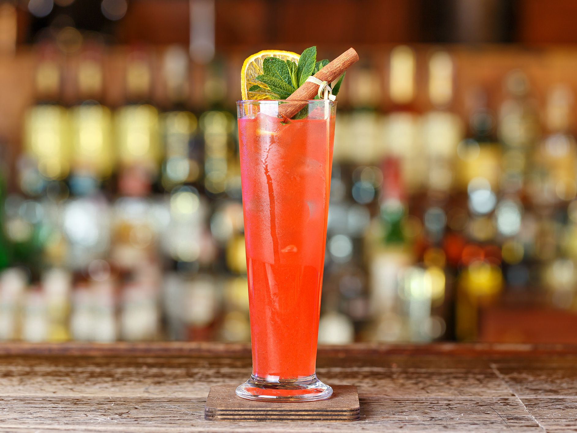 Cocktail classic sling based on strong alcohol, lemon juice, syrup, liquor, soda and mineral water. Cocktail on the bar counter. Space for text