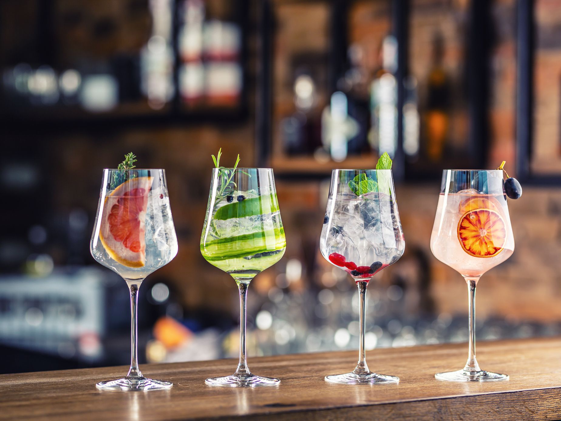 Gin tonic cocktails in wine glasses on bar counter in pup or restaurant.
