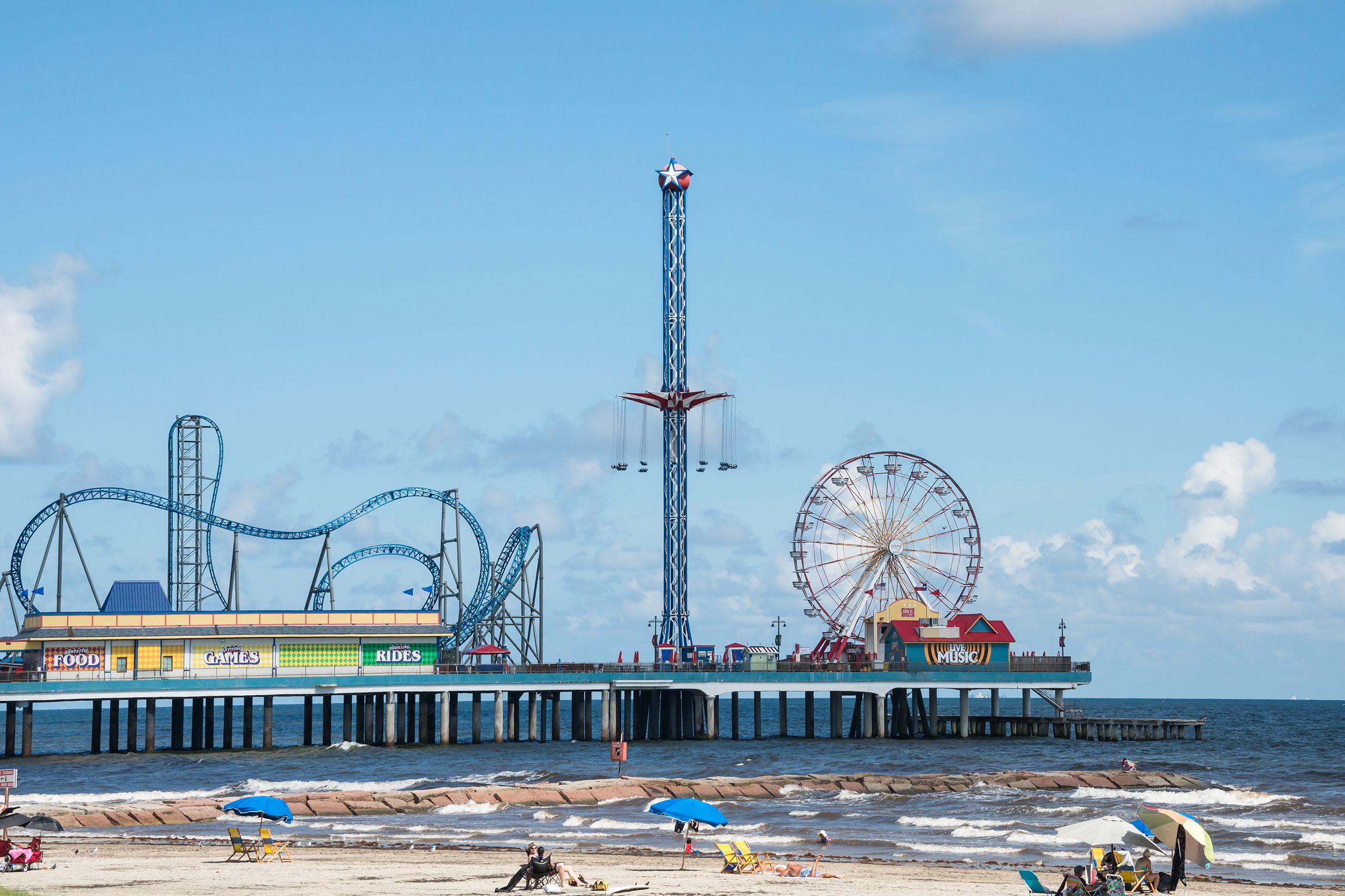 Pleasure Pier amusement park and beach, Galveston, Texas, beach in the foreground, on a sunny day