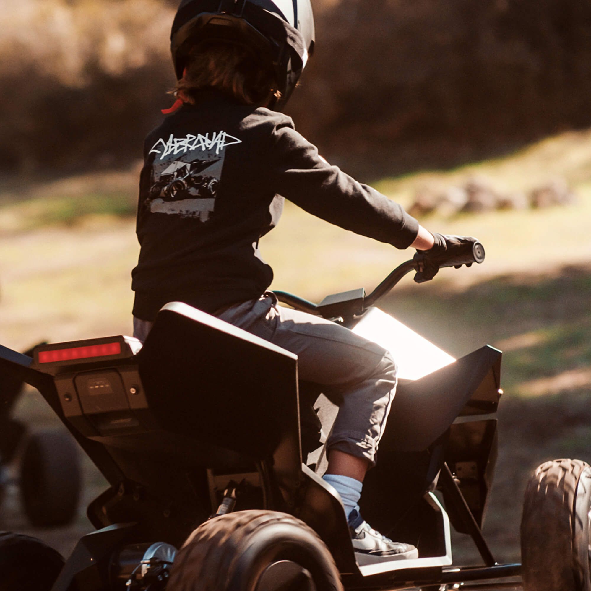 Male child riding a Tesla Cyberquad for Kids outside