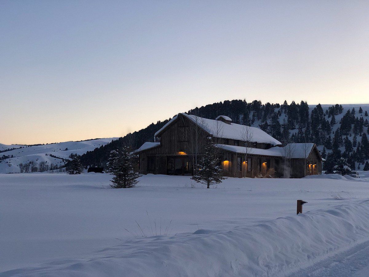Large cabin at dusk in deep snow.