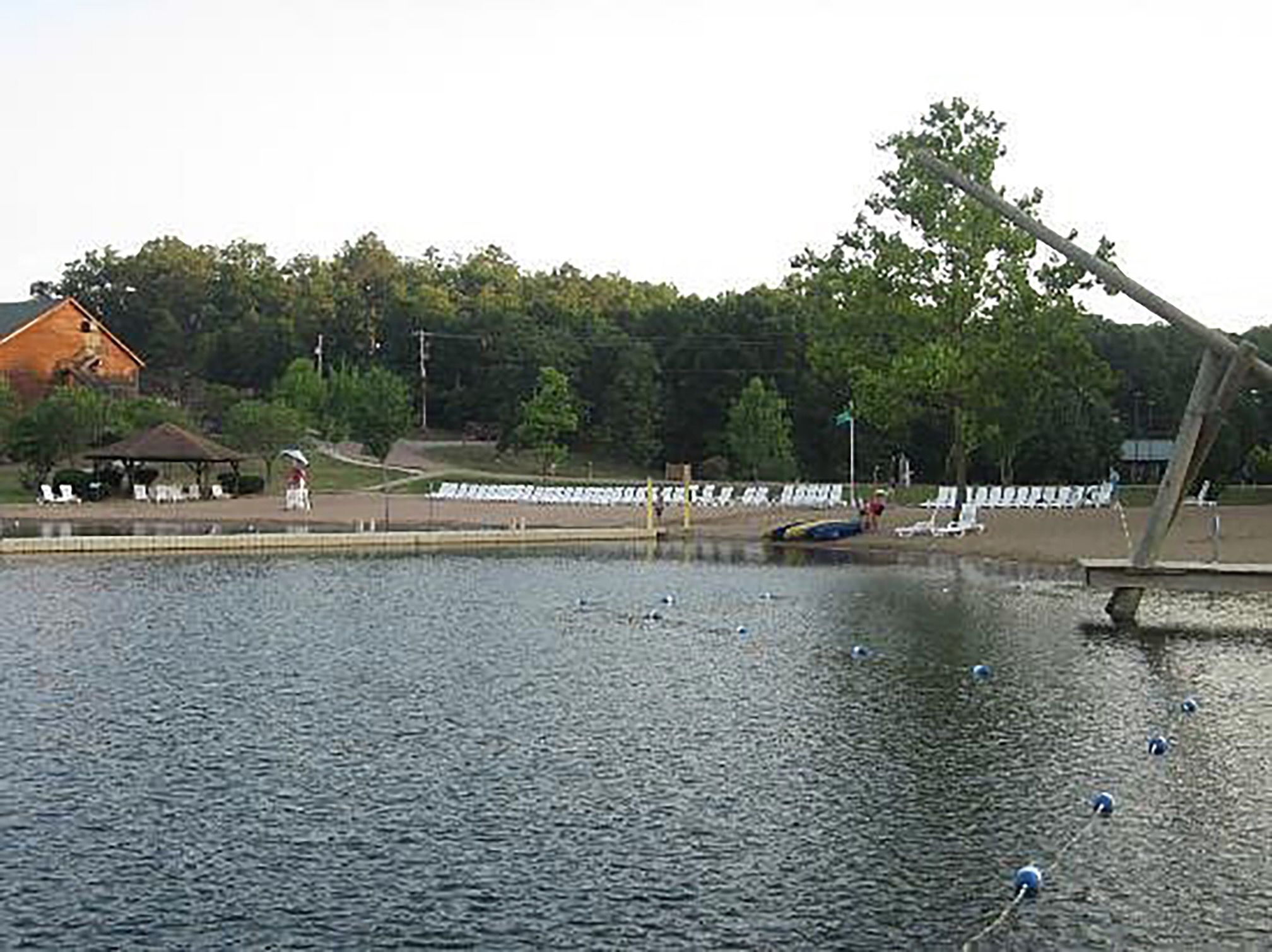 White lounge chairs around a lake on overcast summer day.