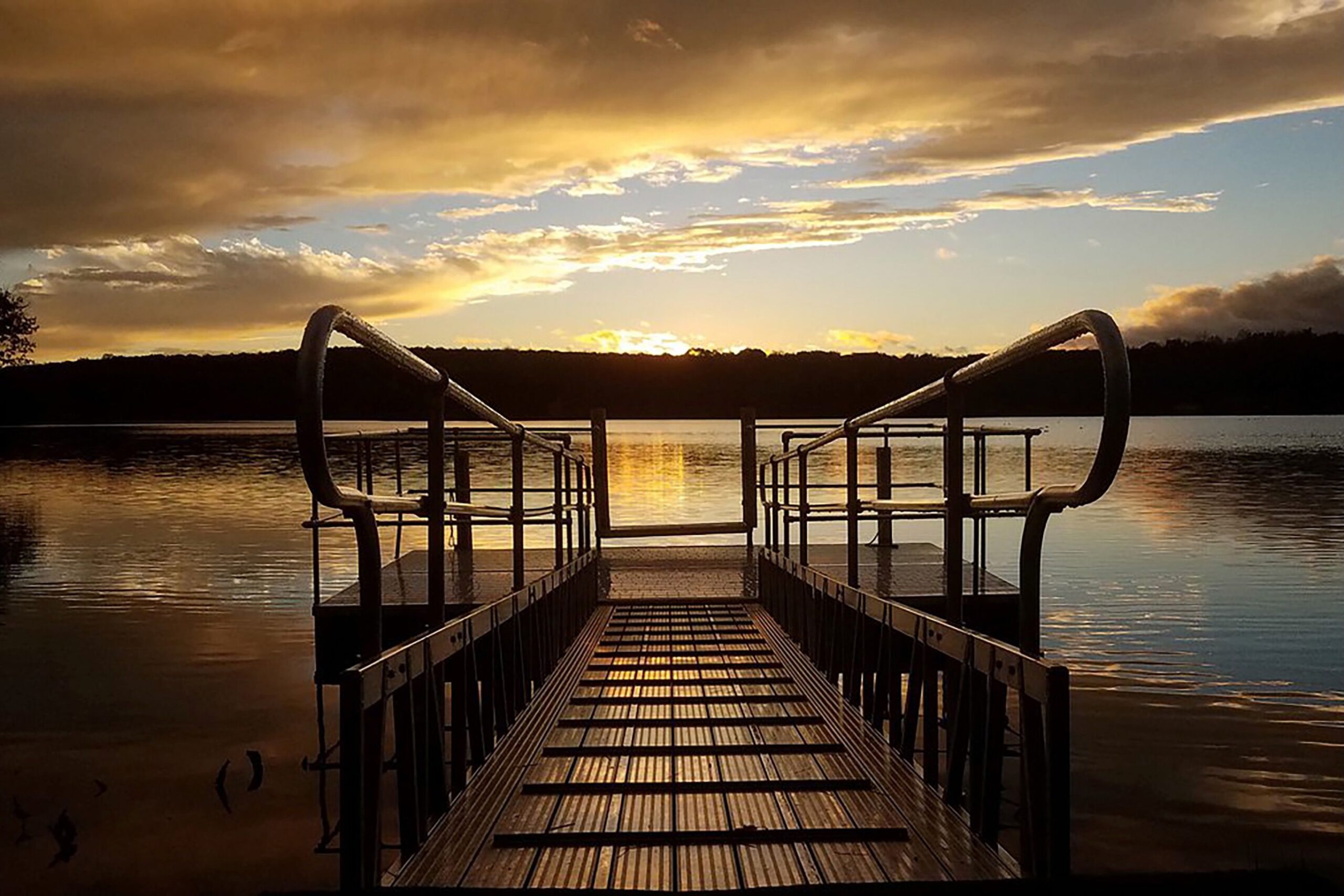 Boardwalk on a lake at sunset.
