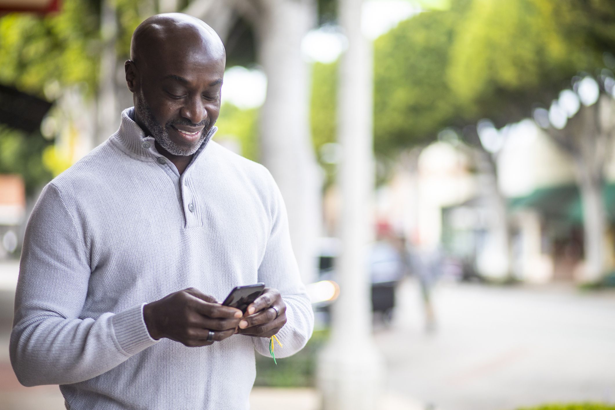 man looking at phone on sunny day