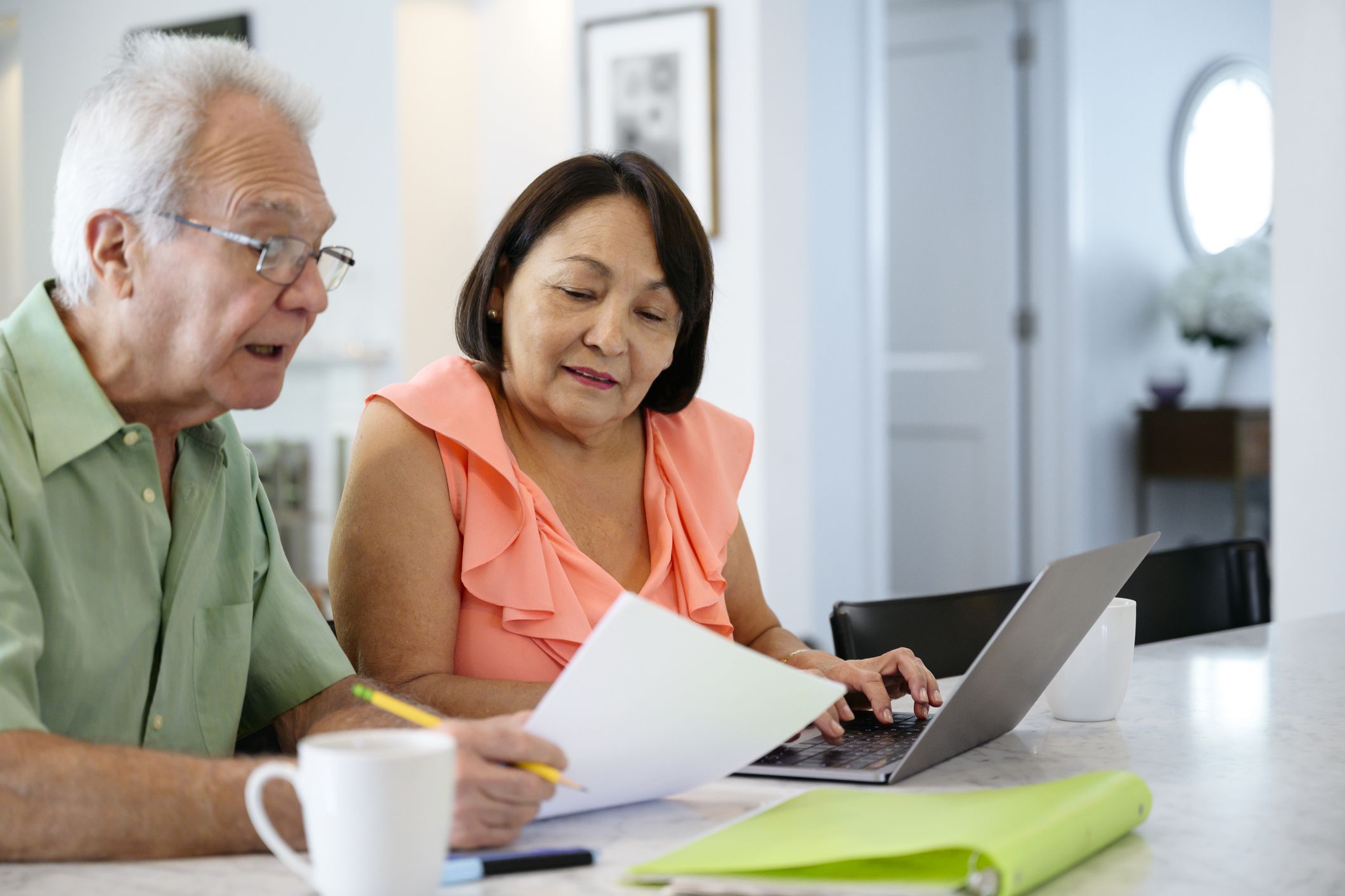 Focused Latin American male and female senior couple using laptop to help organize their retirement plans.