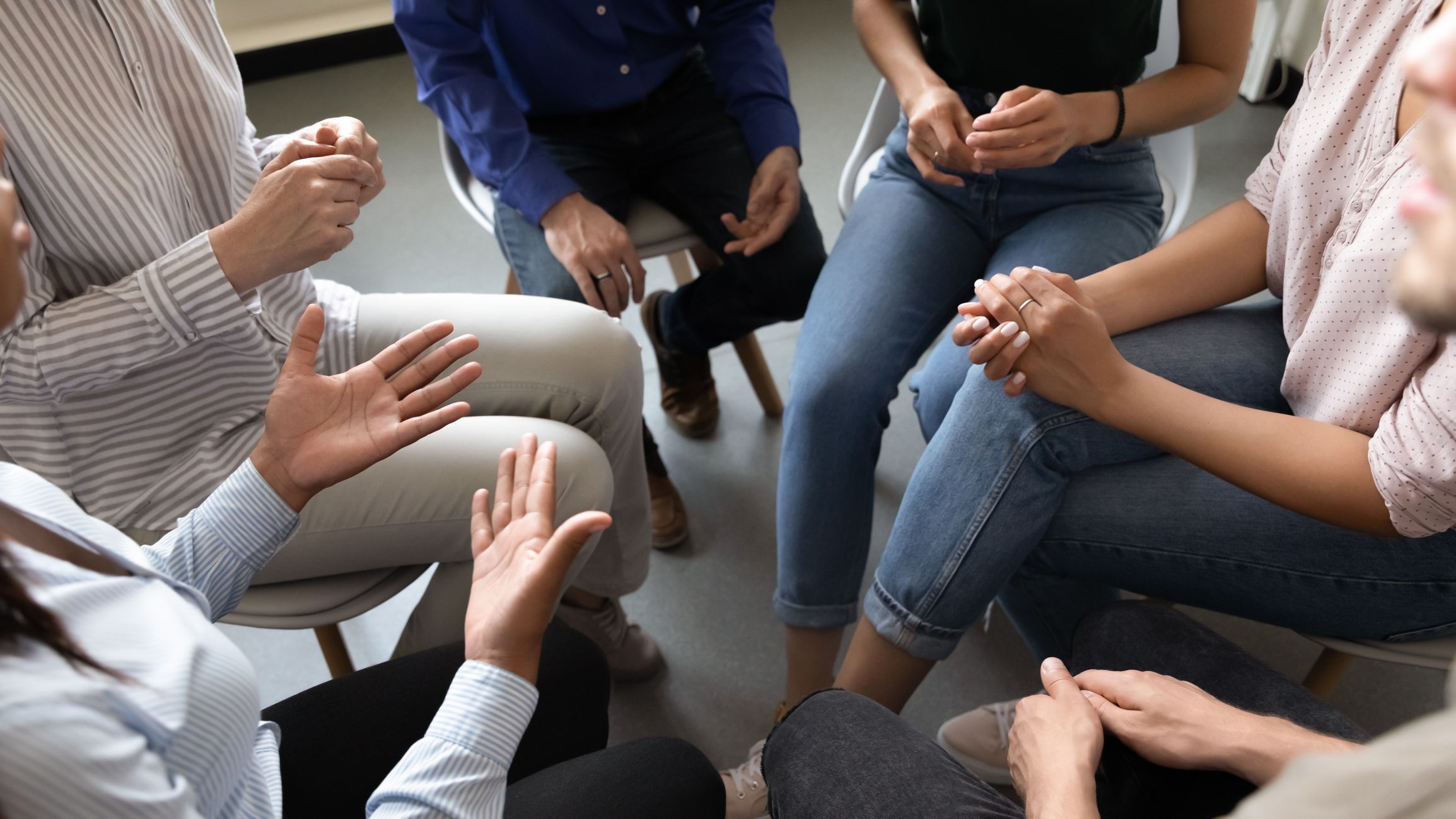 Top close up view in circle sit people, corporate teambuilding activity solve issues talk think together or alcohol rehab addiction treatment, twelve-step program, physical, mental, spiritual concept