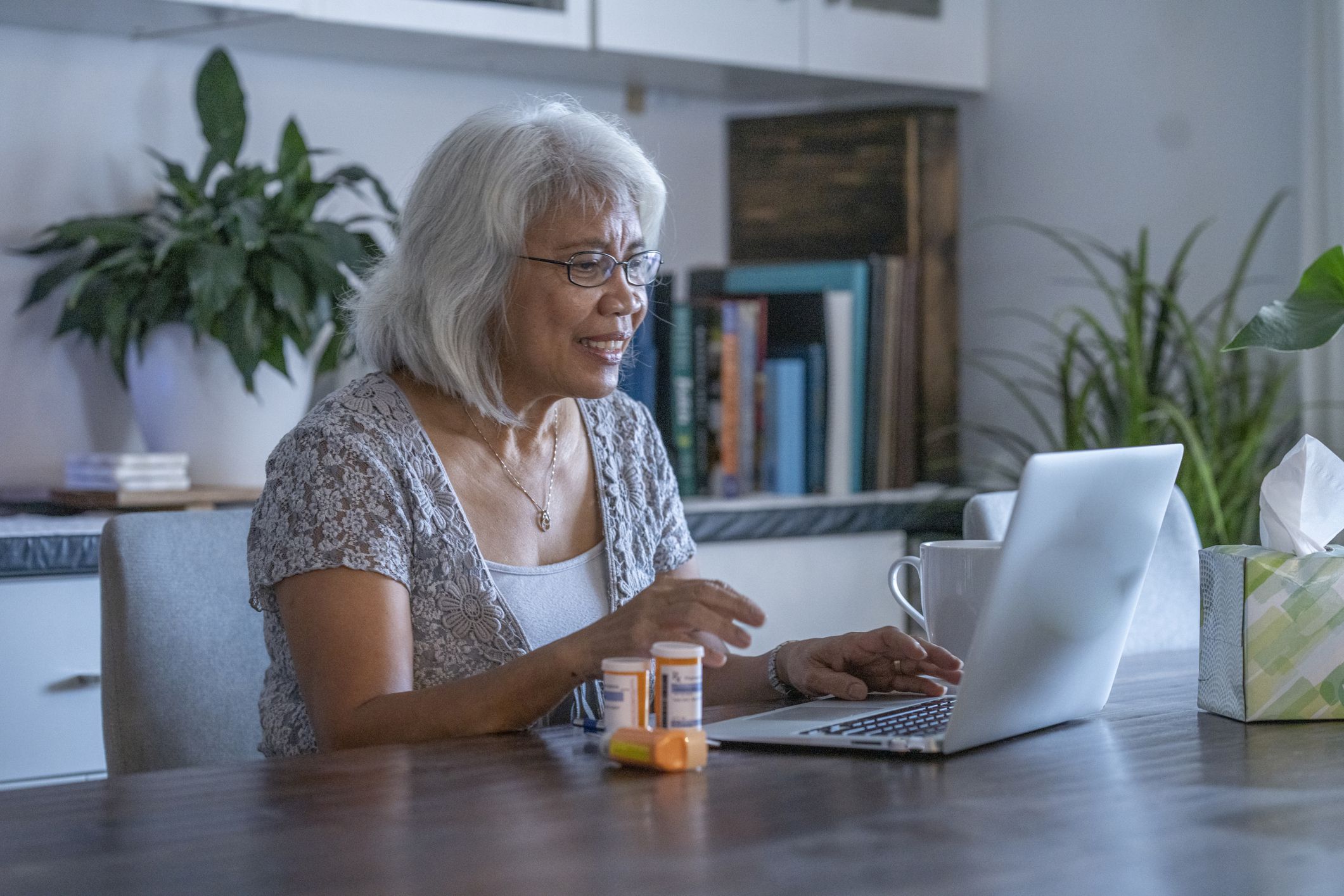 A woman asks her doctor questions on her laptop from the safety of her home.