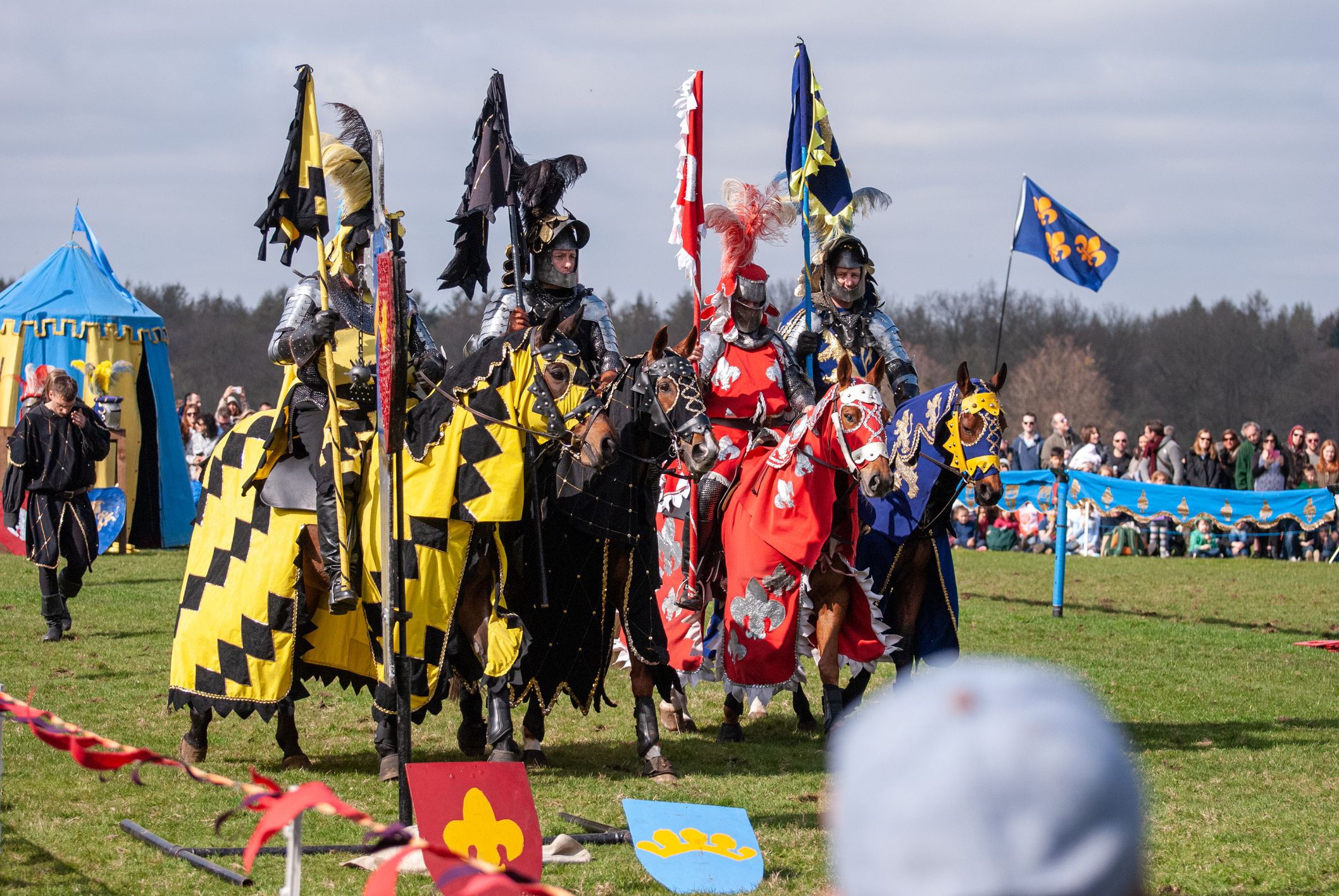 Medieval horseback jousting display and sword fighting with knights in shining metal armour at Knebworth house, England.