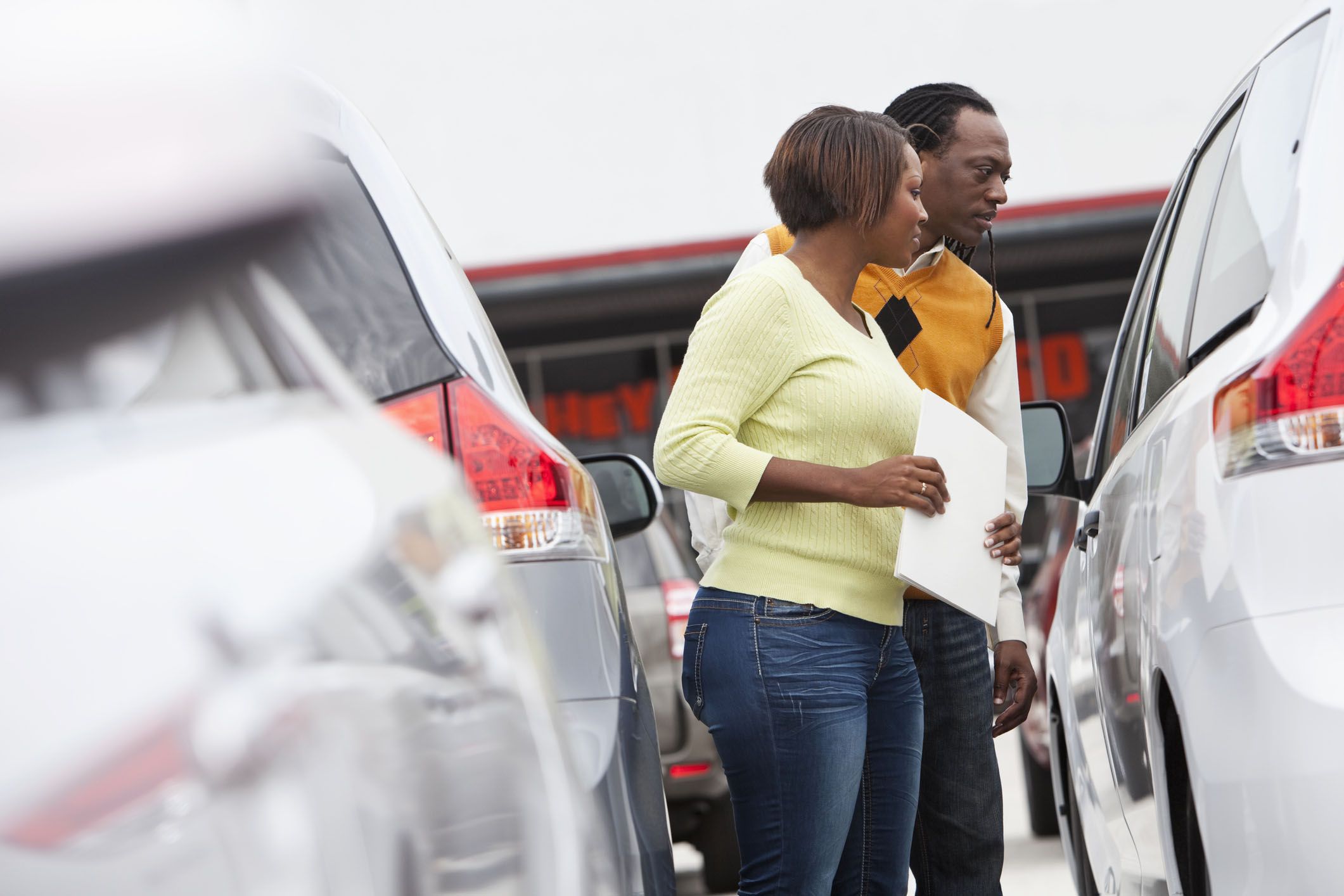couple inspecting car in lot