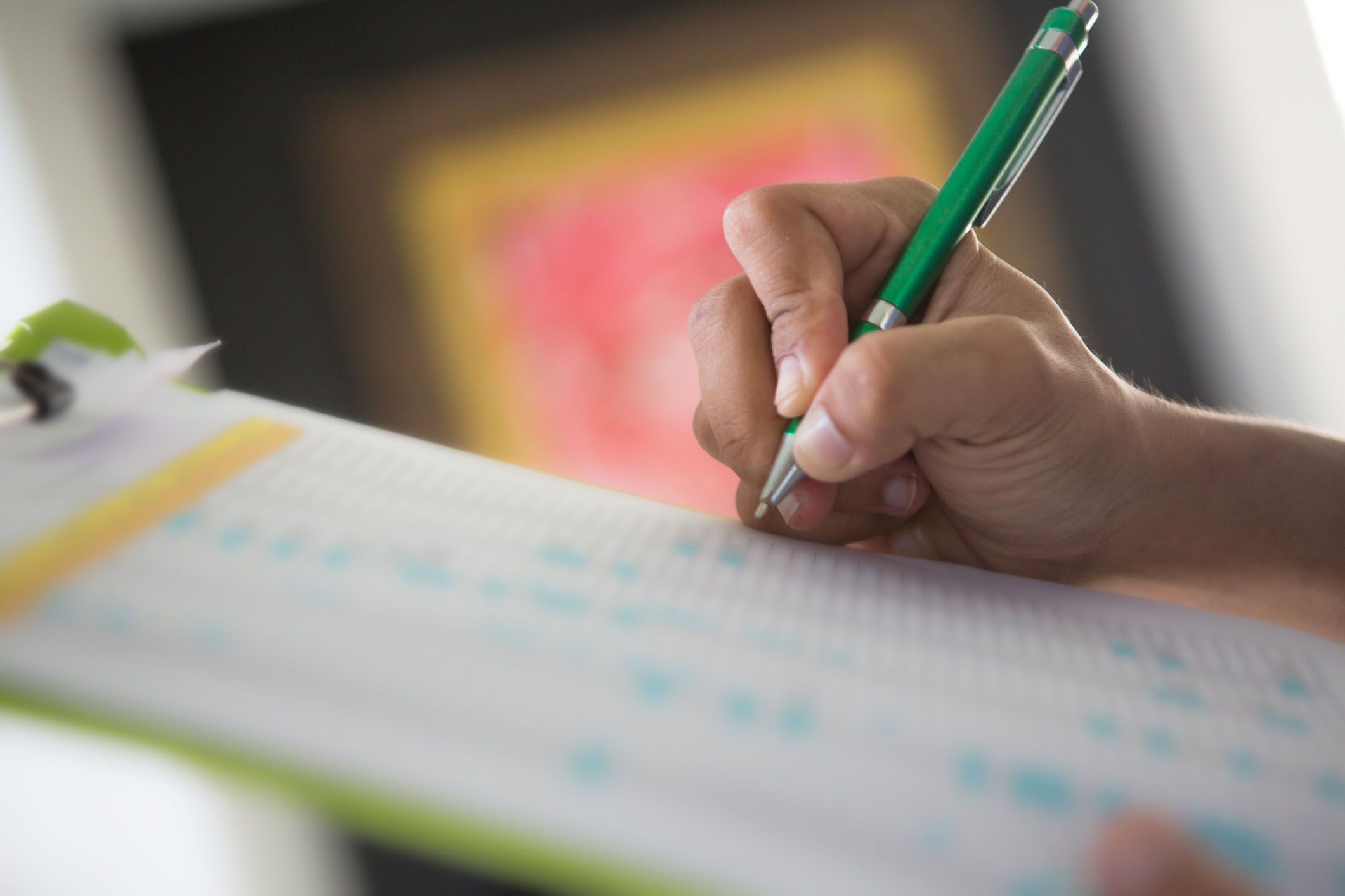 hands writing on list on clipboard