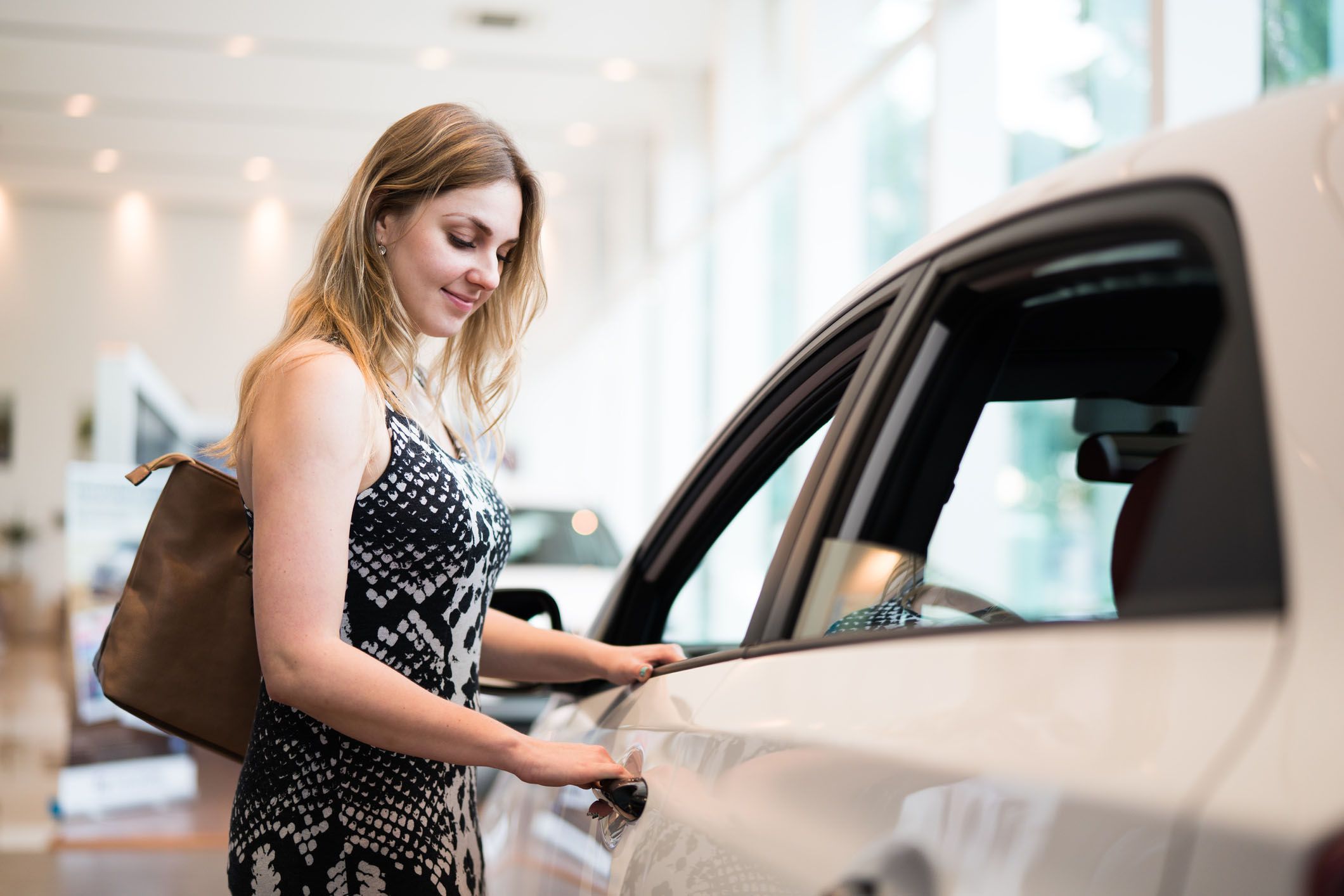 young person looking at car smiling