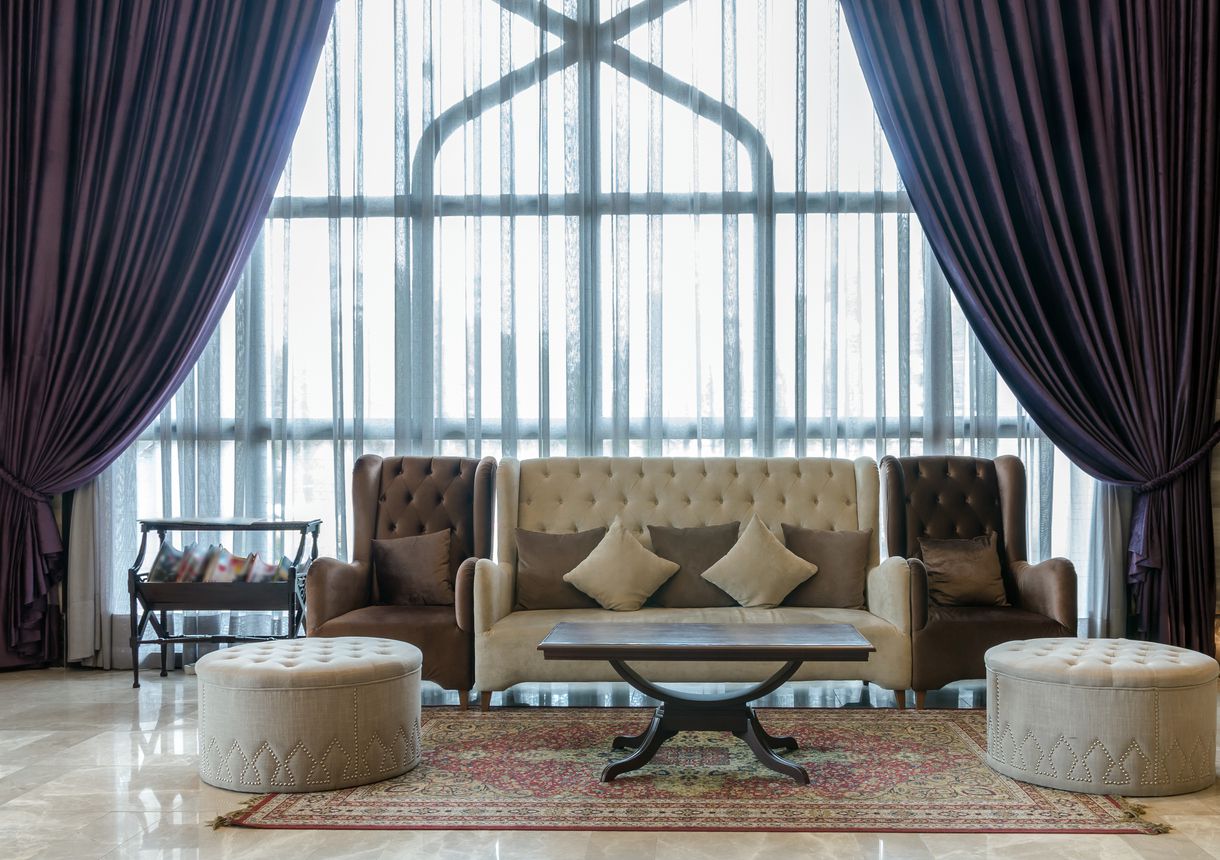 Lobby area of a hotel with fancy velvet beige and brown furniture