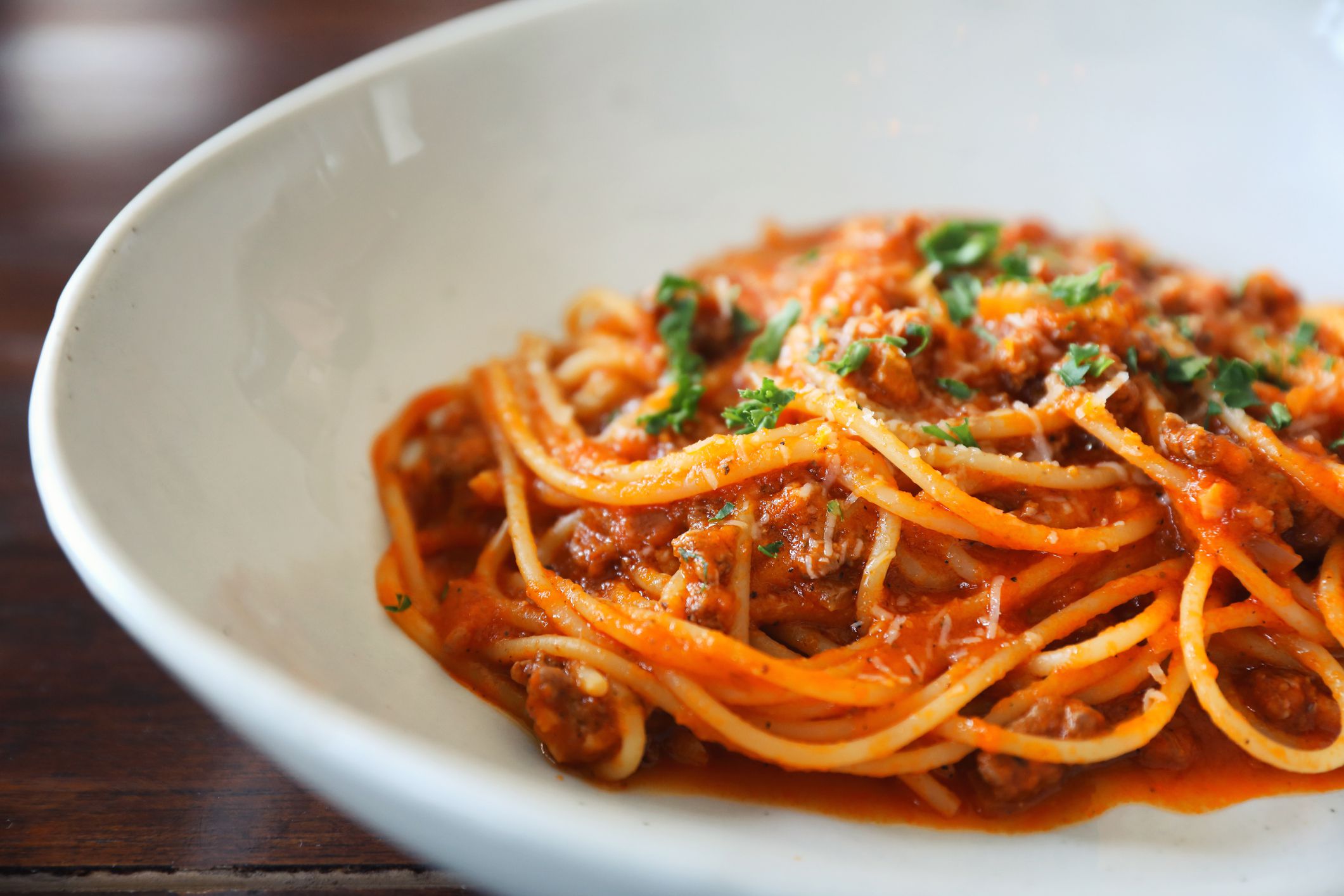 Closeup of 10 minute instant pot spaghetti in a white plate with a blurred background of a wooden table