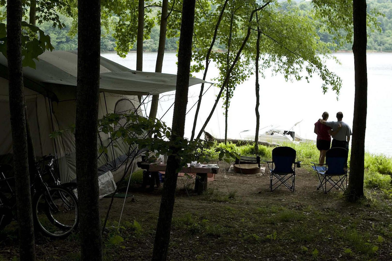 Briar Point Campground, Roanoke, West Virginia, couple hugging while looking out onto the lake with a tent in campsite in the background