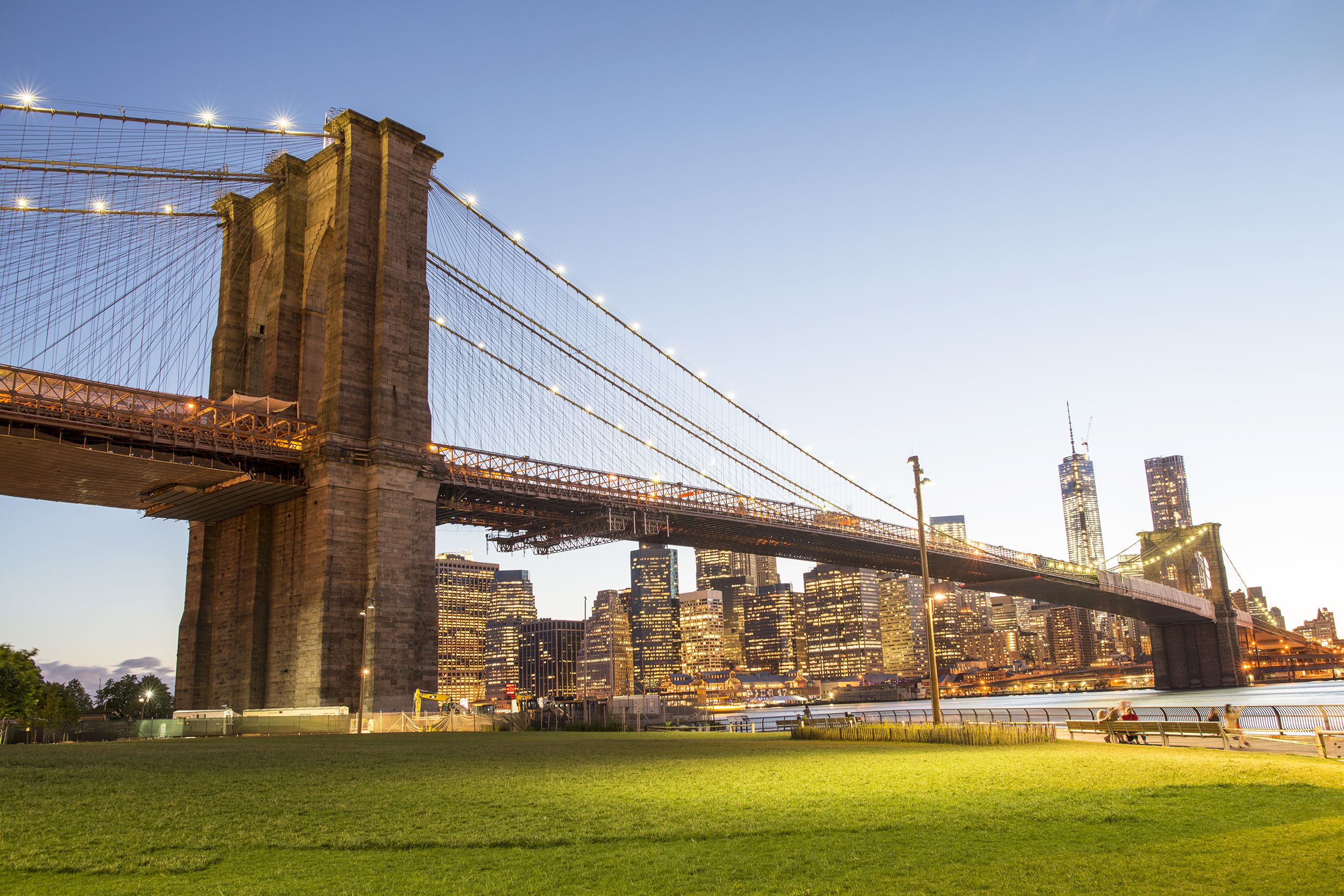 Brooklyn Bridge Park, Brooklyn, park in the foreground with the Brooklyn Bridge behind it, lower Manhattan in the background, during dusk, well-lit