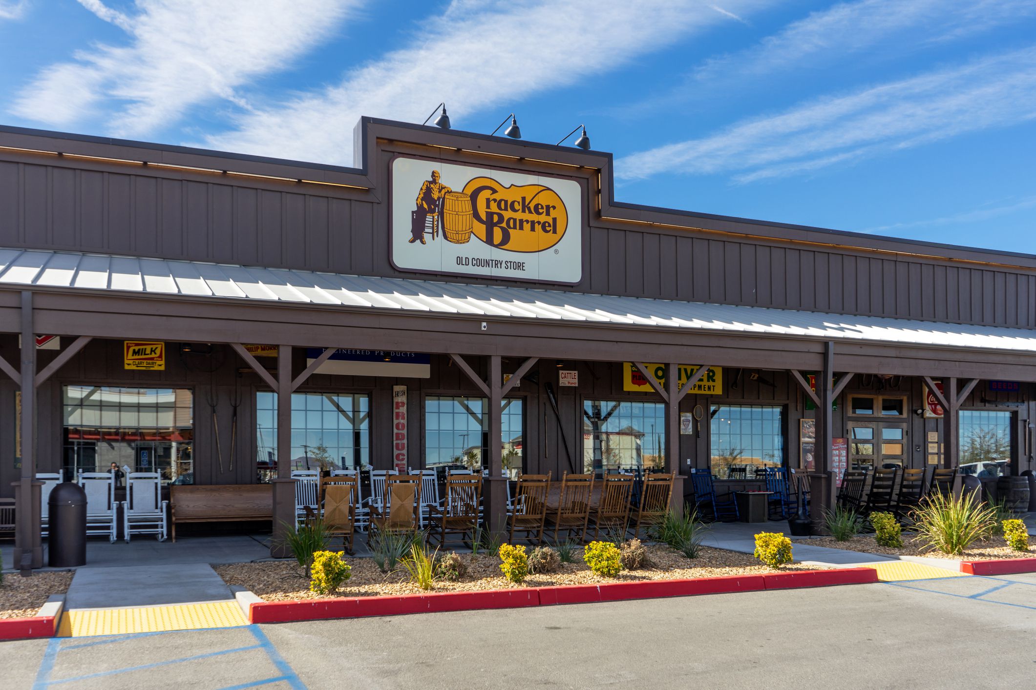 Exterior of a Cracker Barrel restaurant in Victorville, California with an empty parking lot with a blue sky in the background