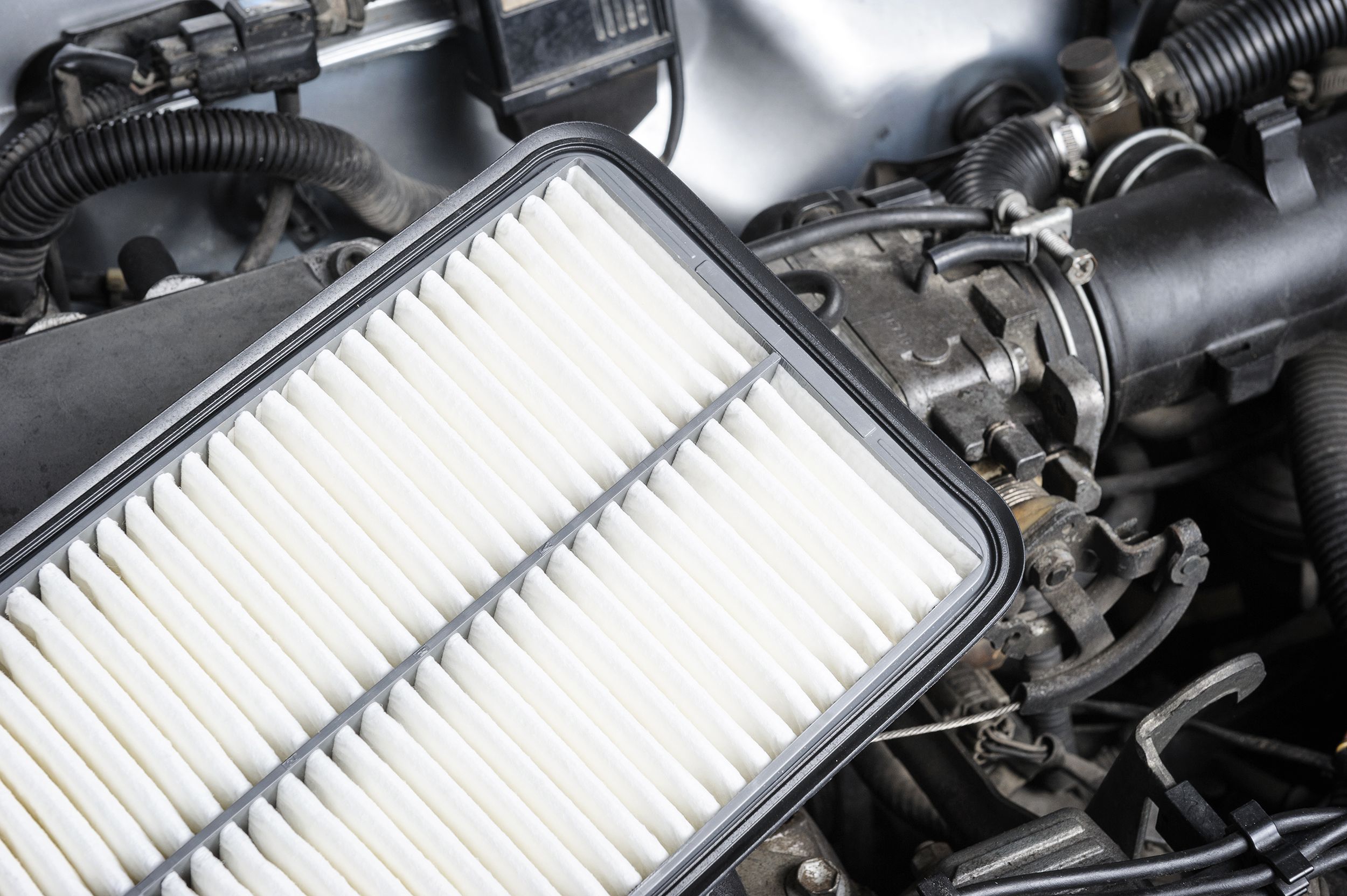 New car air filter layer on the car's engine, diagonal, clean car engine in the background
