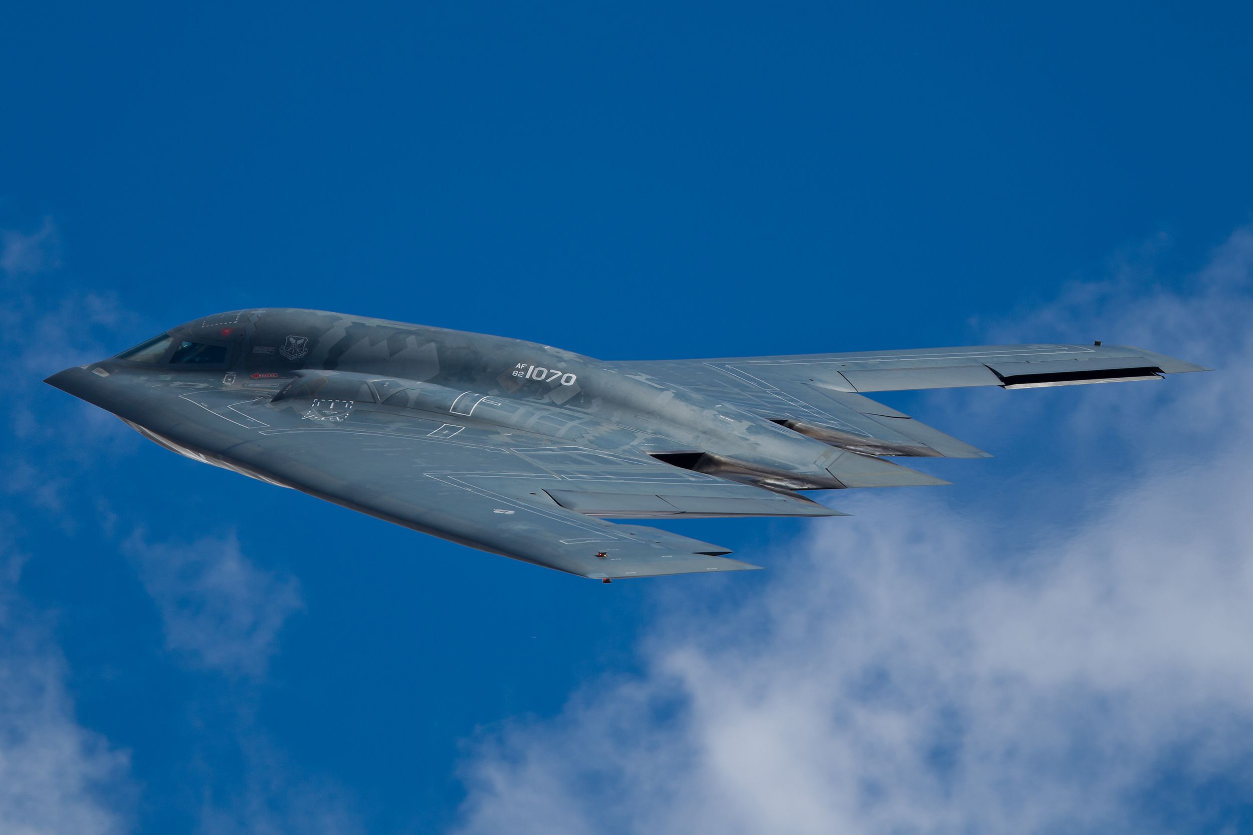 Northrop Grumman B-2A Spirit (Spirit of Ohio) flyby demonstration during Air Expo at McChord Field Joint Base Lewis-McChord, Tacoma, Washington, bright blue sky with white clouds along the bottom of the image
