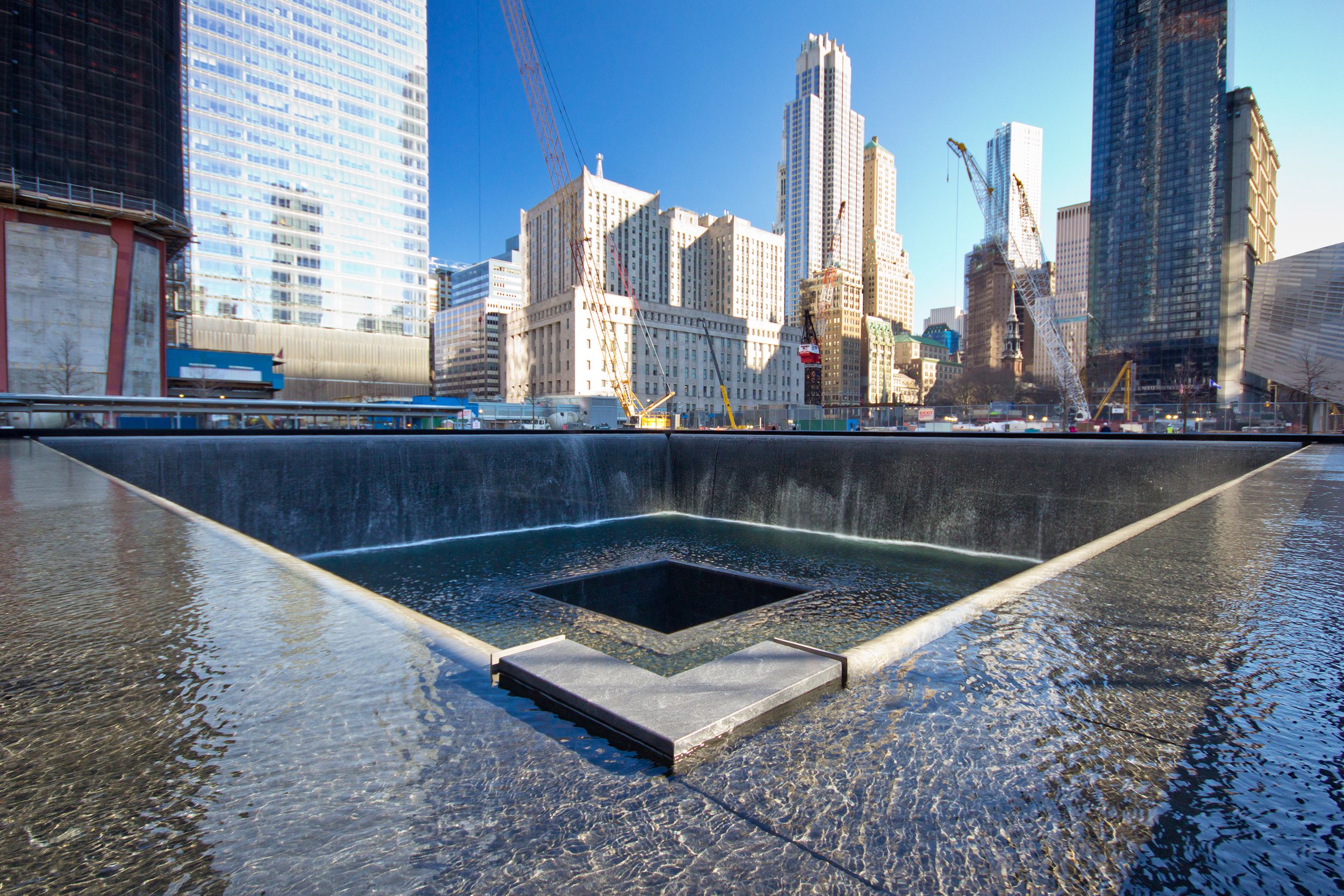 Closeup of a Reflecting Pool of the 9/11 Memorial at the World Trade Center Ground Zero, the Financial District, Manhattan, skyscrapers in the background on a sunny day