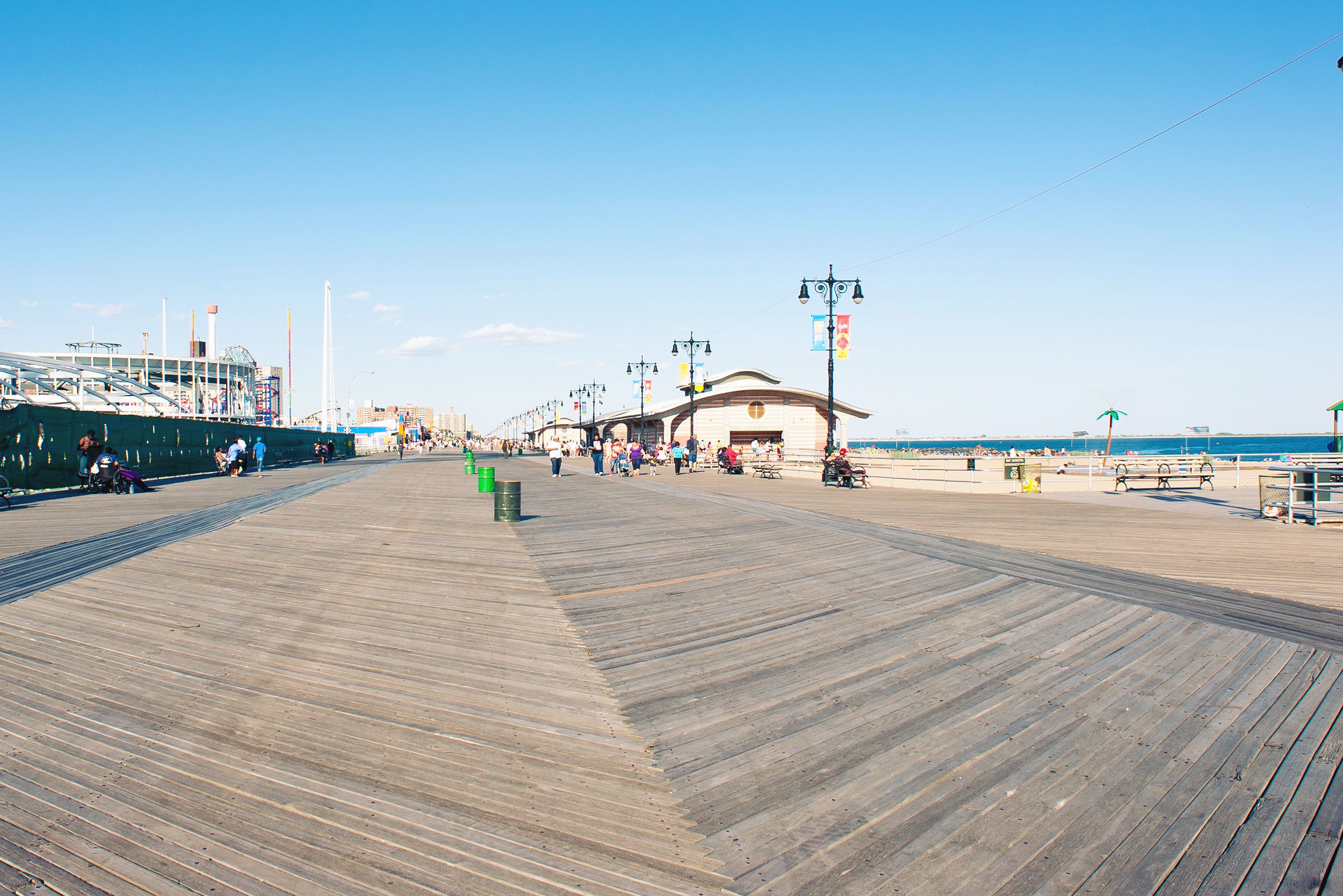 Riegelmann Boardwalk in Coney Island, New York City, clean, rides on the left background and ocean on the right background, on a sunny day