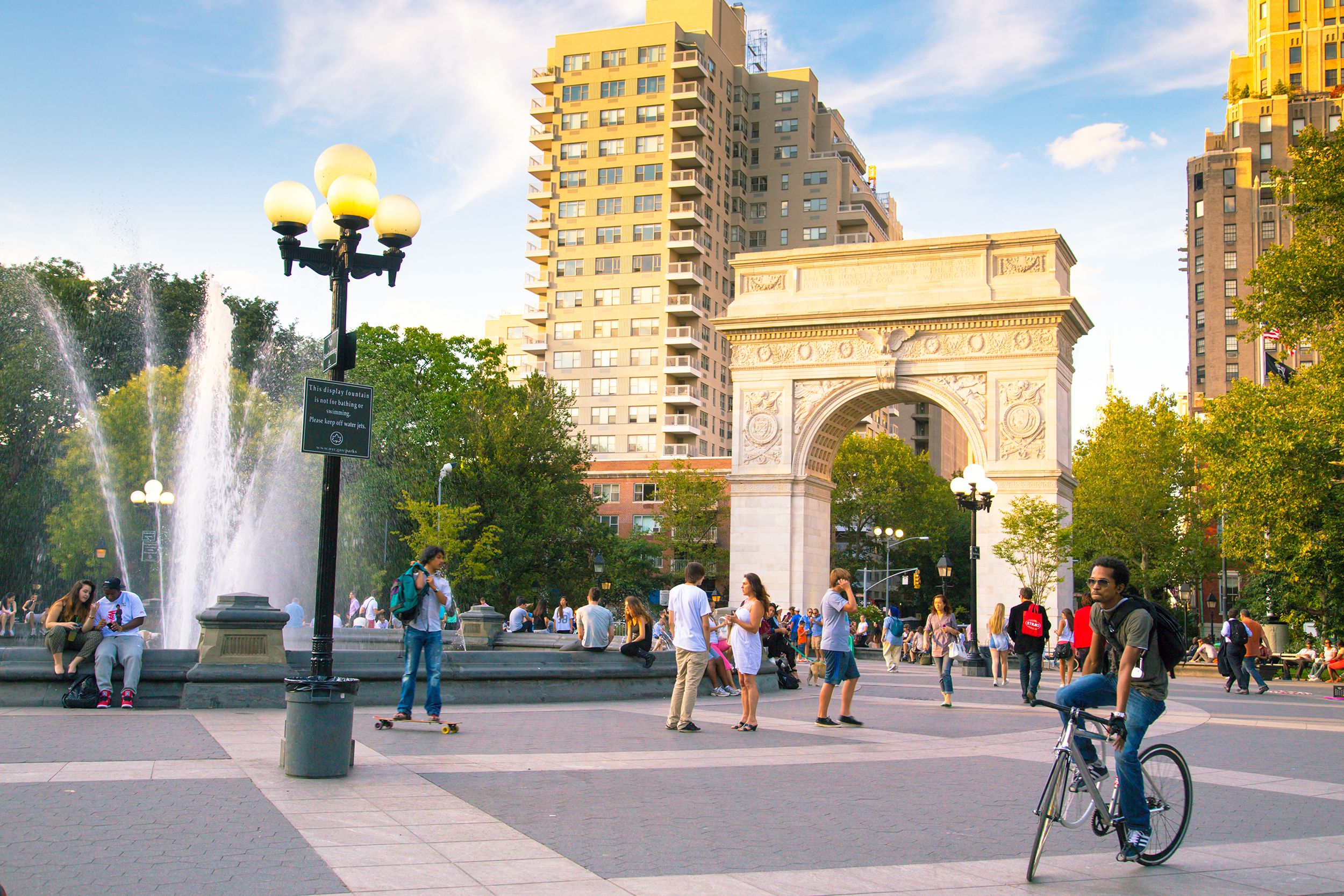Washington Square Park, Manhattan, people enjoying themselves during sunset in the summer, arch and buildings in the background