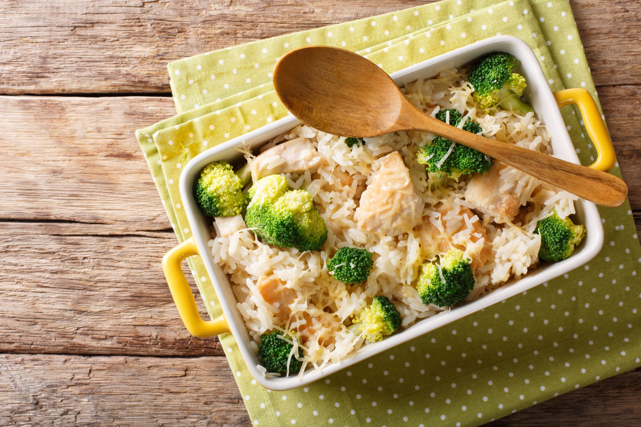 Dietary foods: rice baked with broccoli, chicken and cheese close-up in a baking dish. horizontal top view from above