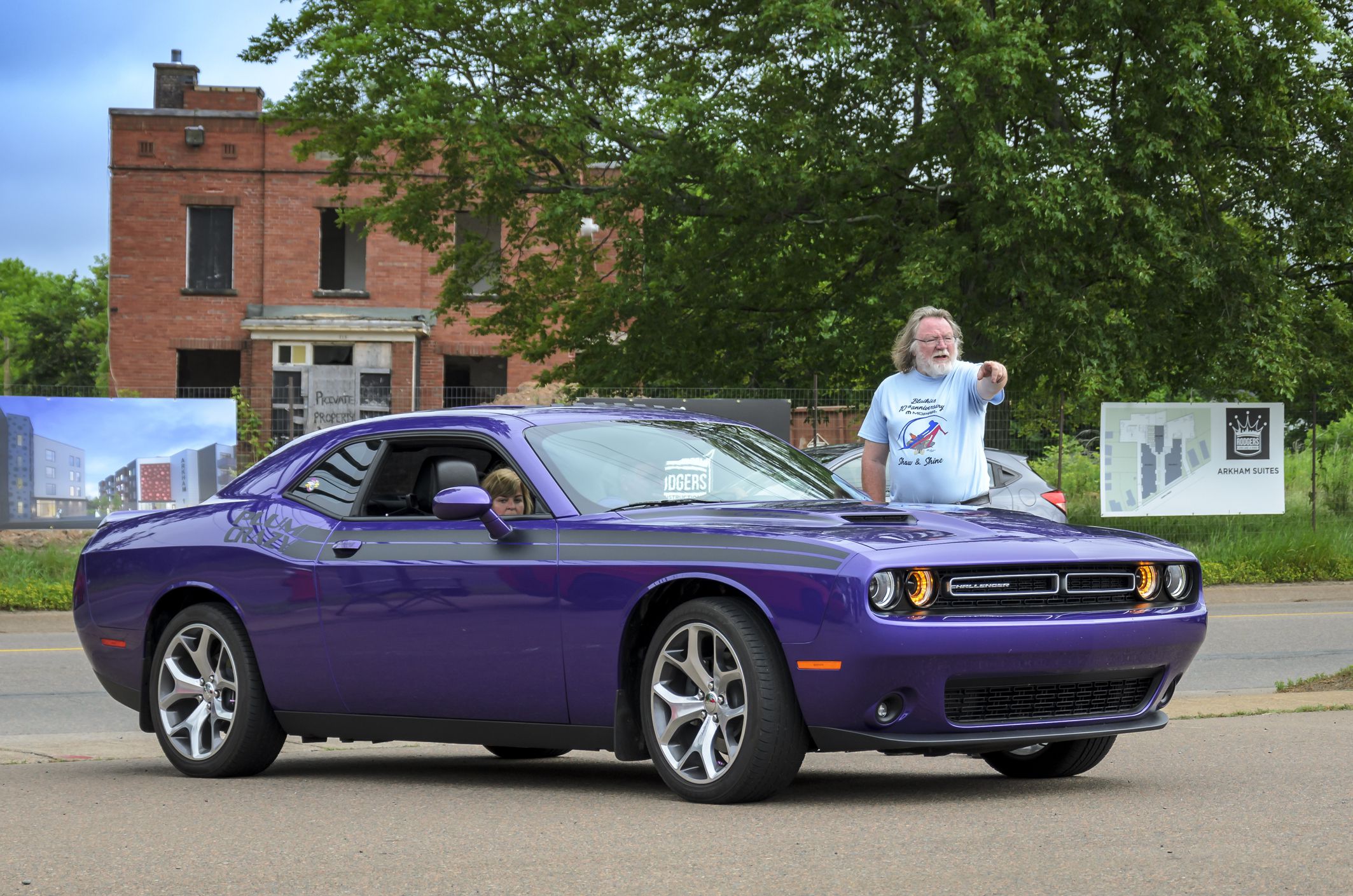 Truro, Nova Scotia, Canada - July 14, 2019 : Modern Dodge Challenger at annual Blaikies Mopar Show & Shine. Car show parking attendant directs driver to a parking spot.