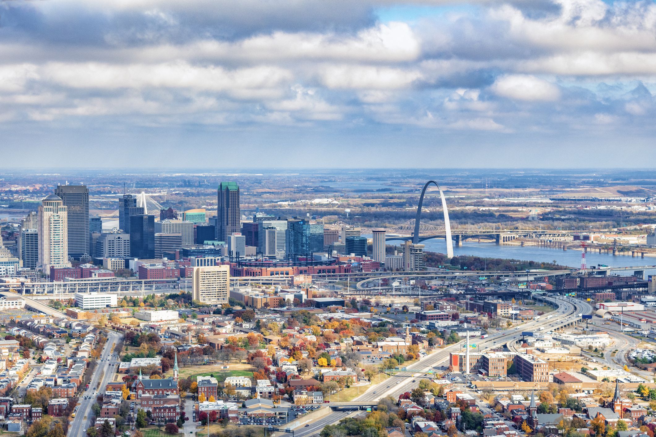 The skyline of St. Louis, Missouri along the banks of the Mississippi River shot from a distance at an altitude of about 1000 feet.