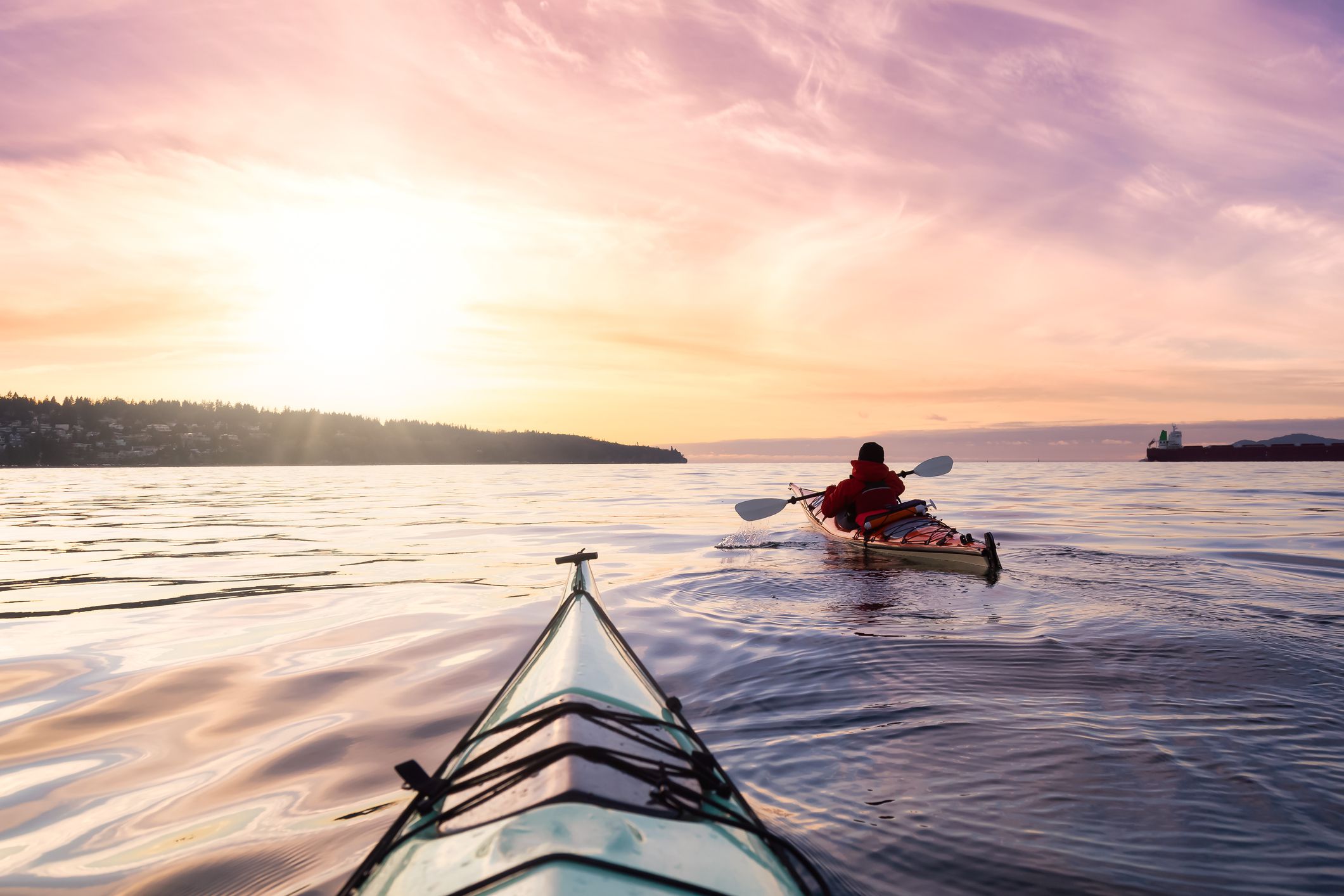 Adventurous Man Sea Kayaking in the Pacific Ocean. Dramatic Colorful Sky Art Render. Taken in Jericho, Vancouver, British Columbia, Canada.
